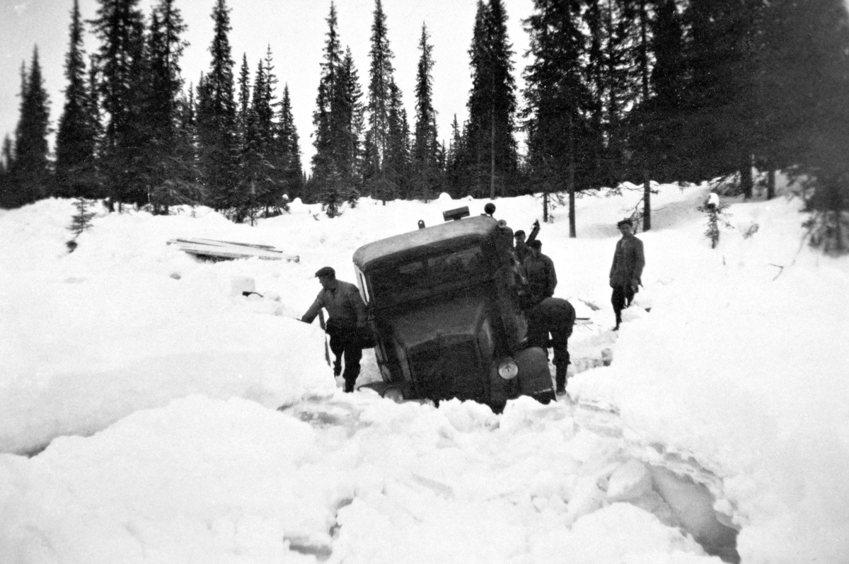 Anno Domkirkeodden, Lastebil, en Man med 6-hjulstrekk har kjørt seg fast i Åsta. Lastebilen kjørte flisfjell fra Flisfjellgruva ved Beskjedalen, Furnes Almenning. Vinter 1946. Karen t. v. er Oskar Ellefsæter og han som står ved framskjermen er trolig sjåfør Hans Jonsdal, bakenfor trolig Kristian Bakken og lengst t. h.…