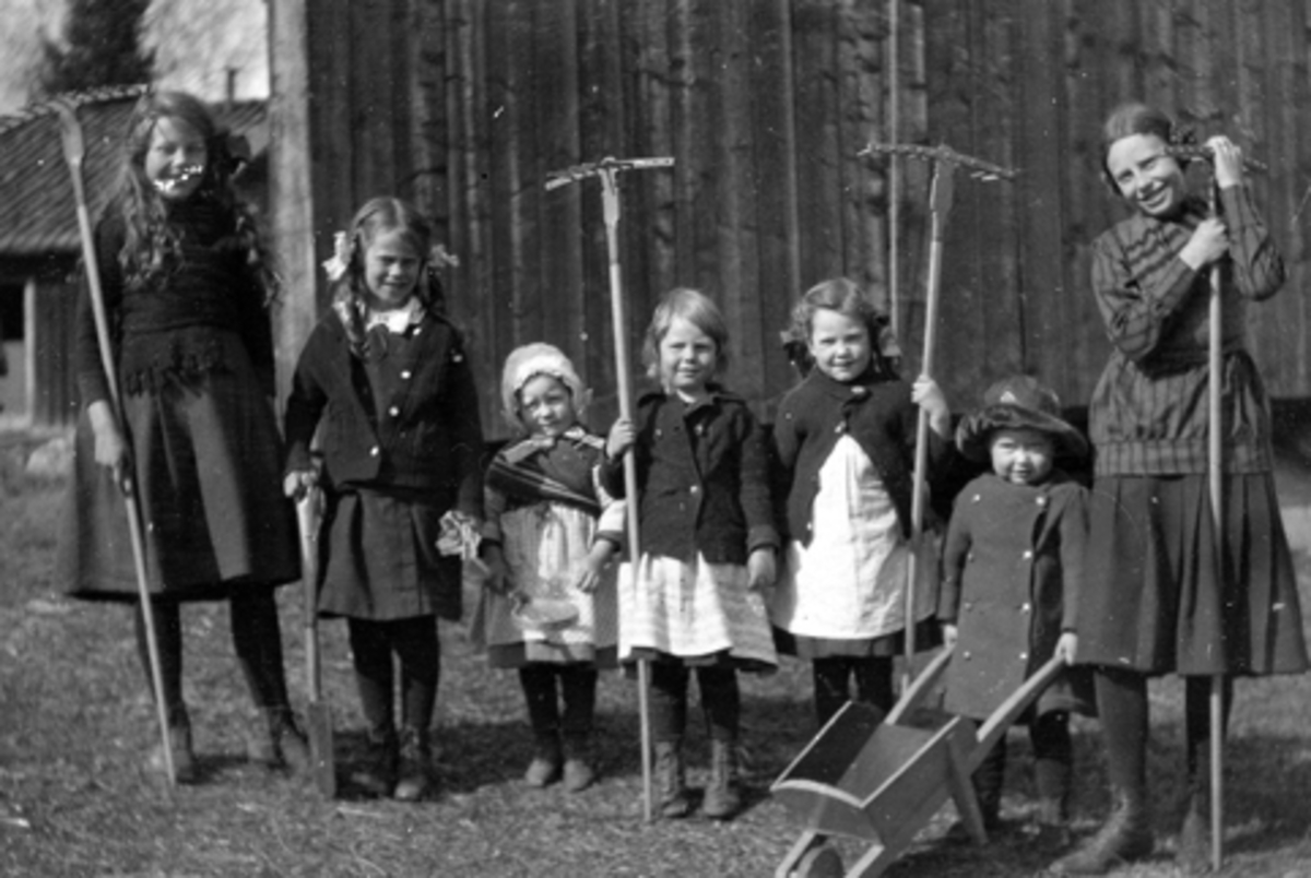 Anno Domkirkeodden, Barn med river og trillebår på Grythesetra i Furnesåsen. F.v. Sigrid Petersen, Thorbjørg Petersen, ukjent, Ingeborg Petersen, Aase Christiansen, Odd Berger Christiansen, Ragnhild Petersen. Redskap, rive, leketrillebår. Barneleke, barneklær.