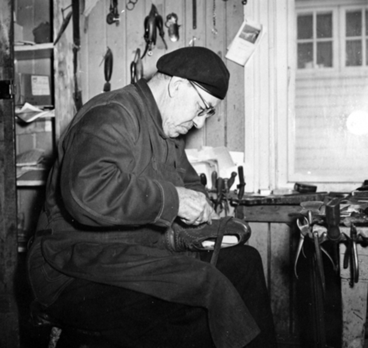 Anno Domkirkeodden, Interiør, skomakerverksted, skomaker Aksel Ludvig Andersen (1887-1966) reparerer sko. Heimdal, Gamlegata 12, Brumunddal.