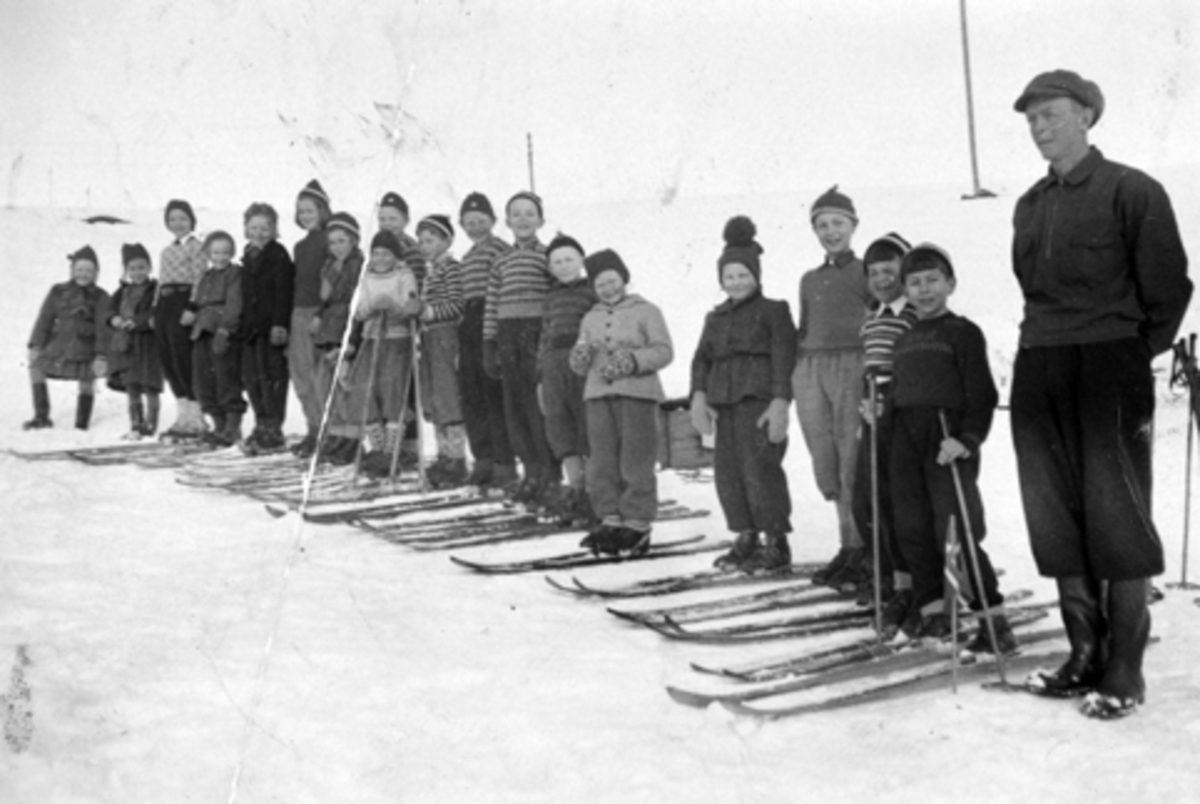 Anno Domkirkeodden, Andre klasse på Mauset skole, Brumunddal på skitur til Lillehovde. Her avbildet sammen med naboer og barn på Lillehovde. Fra venstre er Odny Lillehovde, Jorun Hovde, Solveig Berger, Anne Berit Aalgård, Mary Lillehovde, Anne Marie Hovde, Liv Berit Hovde, Kåre Lillehovde (bak), Willy Westvang (i lys …