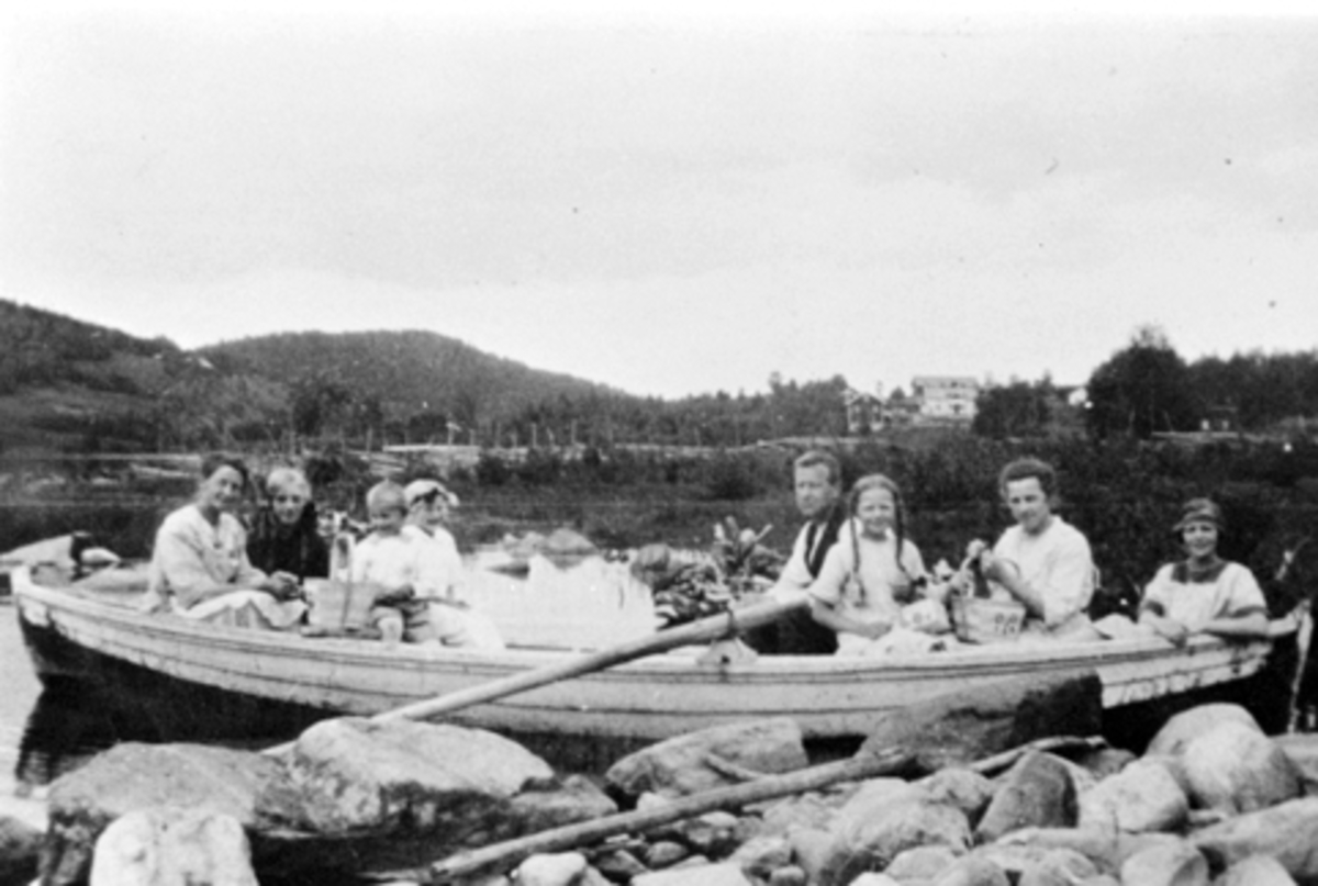 Anno Domkirkeodden, Voksen og barn i robåt på Stavsjøen, Hedmark. Familien Torud med gjester. Fra venstre er Borghild Torud, ukjent, Reidar Torud, Minnie Thorud, Asbjørn, Marit, Dagny (søster til Borghild), Ragnhild Øfsdahl.