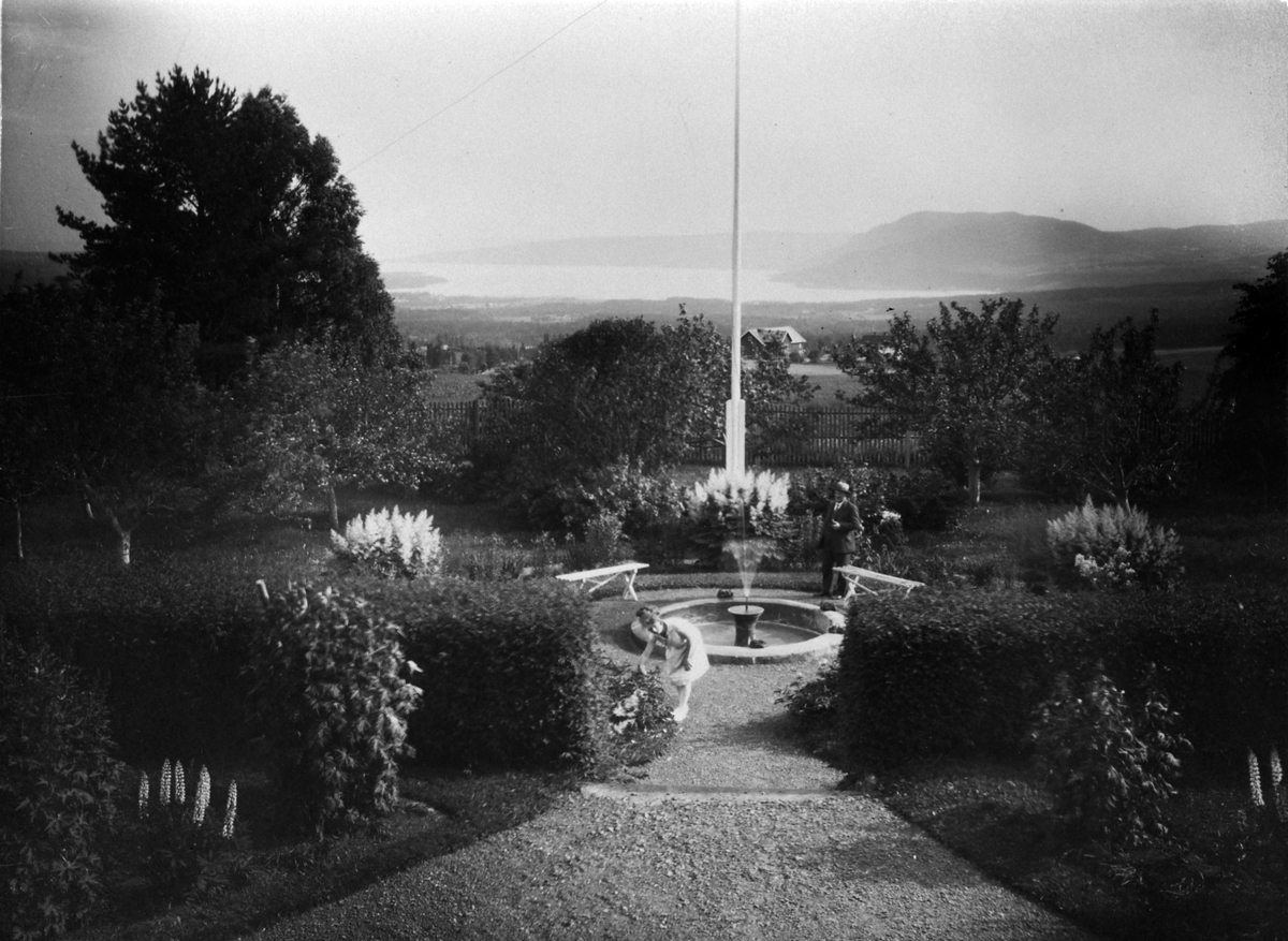 Anno Domkirkeodden, Hageanlegg med fontene og prydbusker på Opsal, Veldre, Ringsaker. Utsikt mot Brumunddal og Mjøsa. Bangsberget i bakgrunn.