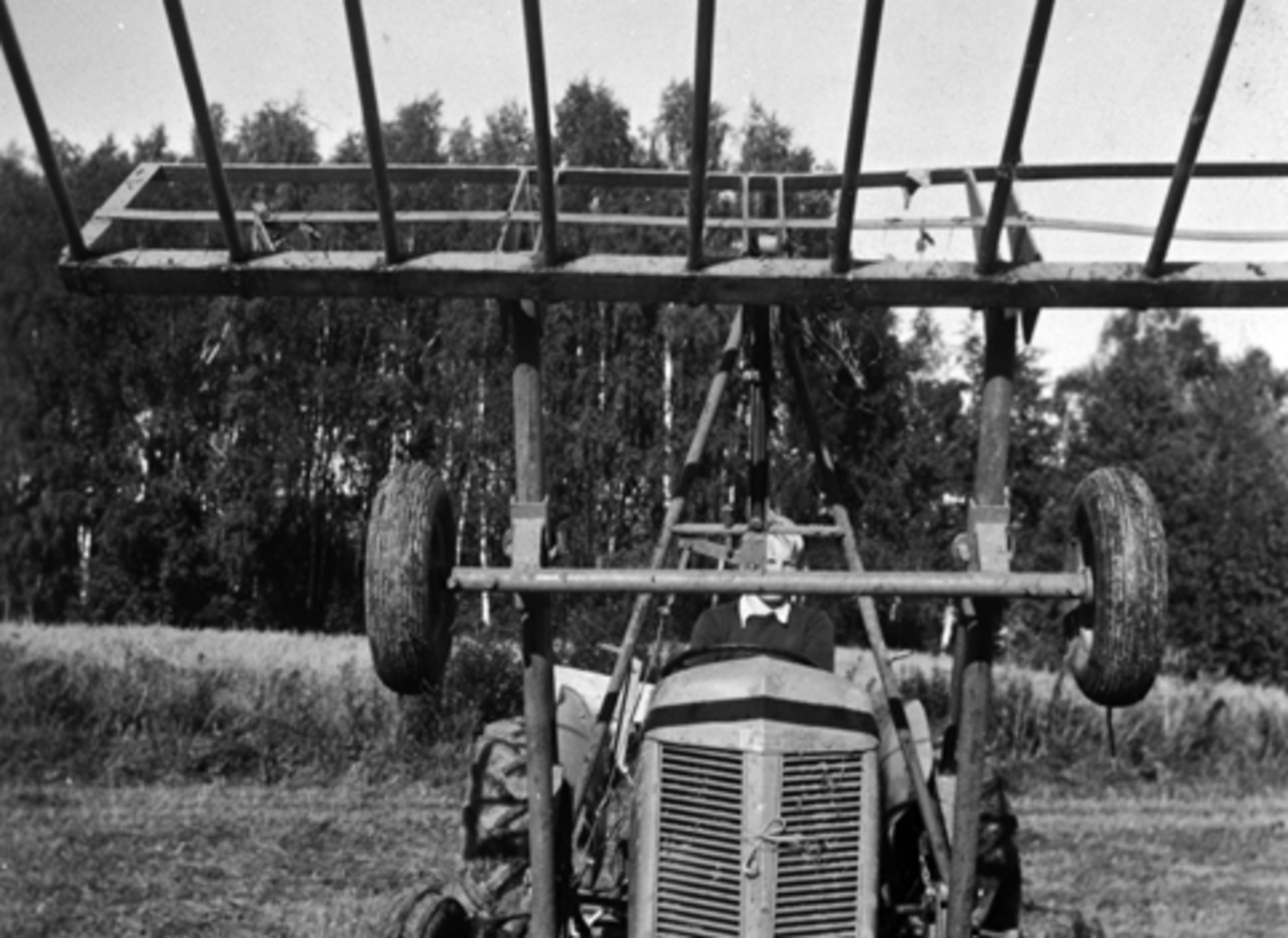 Anno Domkirkeodden, Traktor med silosvans på ukjent sted i Furnes, Ringsaker. På bildet fra 1953 demonstrerer Erik Stafsberg forløperen til silosvansen som ble konstruert av Johan Stafsberg. Senere ble den satt i produksjon av Kverneland Fabrikker på Jæren og ble et redskap på nesten alle garder med grasproduksjon. Hå…