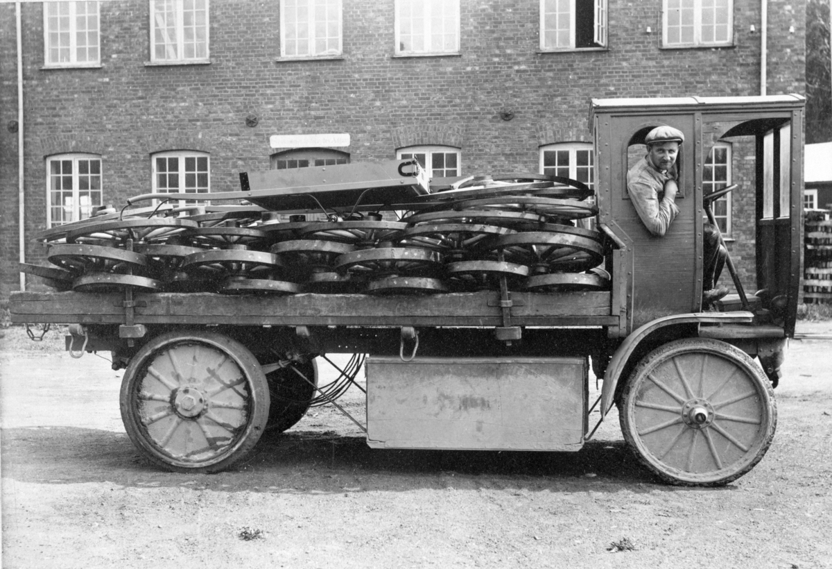 Ukjent, Lastebil ved Moelven Brug, ca. 1915-20, elektrisk drevet. Den hadde store akkummulatorbatterier som ble ladet om natten og de holdt til kjøring hele dagen. Det blir fortalt at den ble kjørt helt inn til Nyskolla. Bilen ble kalt "Galter" og var i bruk særlig for intern bruk på området til Moelven Br…