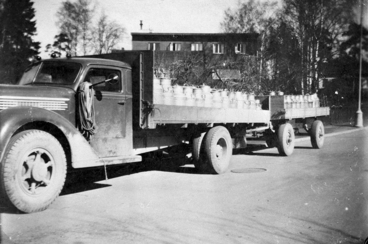 Ukjent, Lastebil med tilhenger, mjølkebil med mjølkespann i Furnesvegen i Hamar. Levering av mjølk til Melkefabrikken. Lars Ulvens lastebil Diamond T, årsmodell 1938-39, med orginalt amerikansk førerhus. Lars Ulven kjørte mjølkerute fra Moelv til Hamar etter krigen