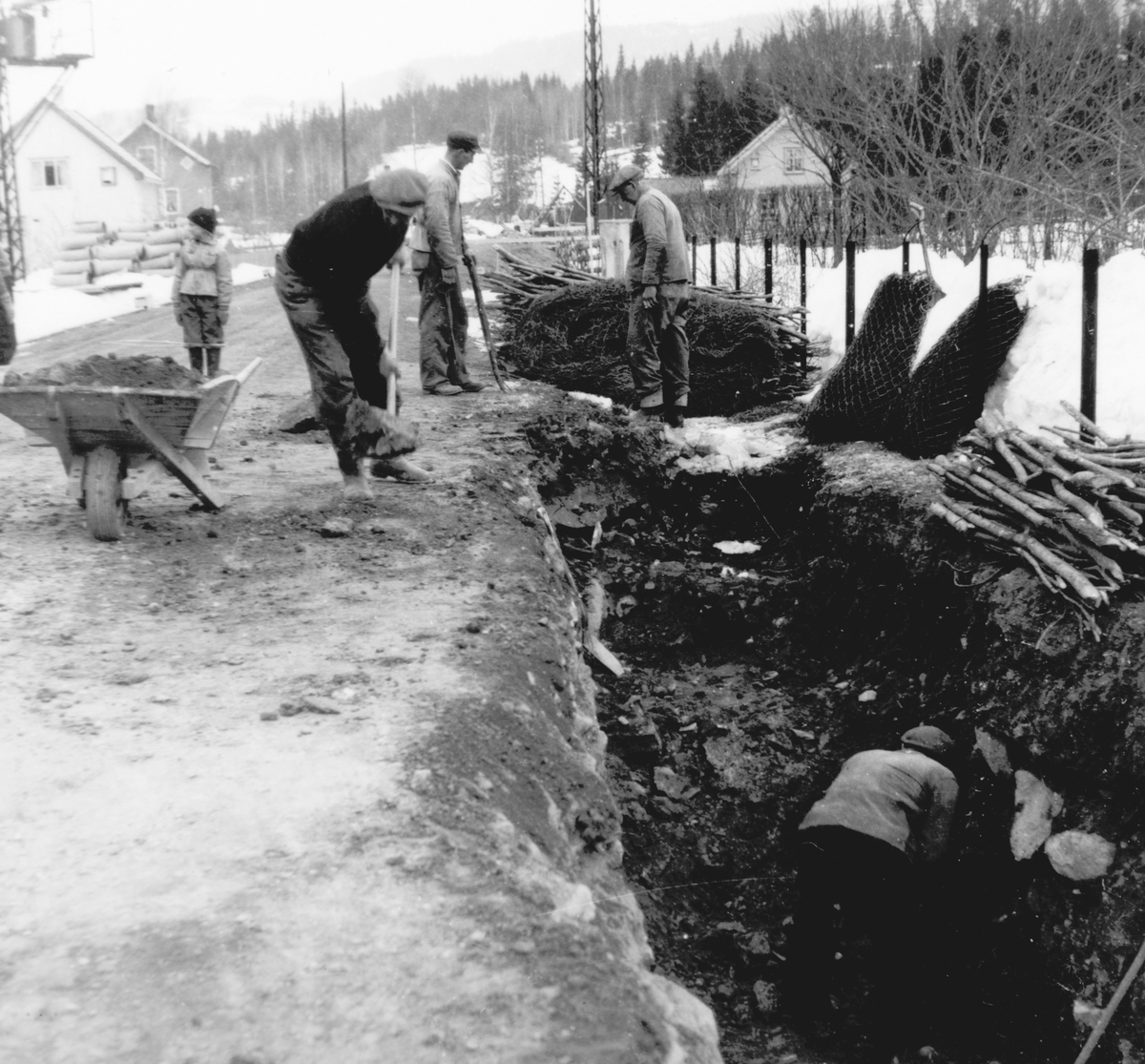 Ukjent, Pinnerudvegen i Moelv. Graving og legging av ny vann og kloakkledning ca. 1952-1955. Graving for hånd, trillebår, spader. Grøft.