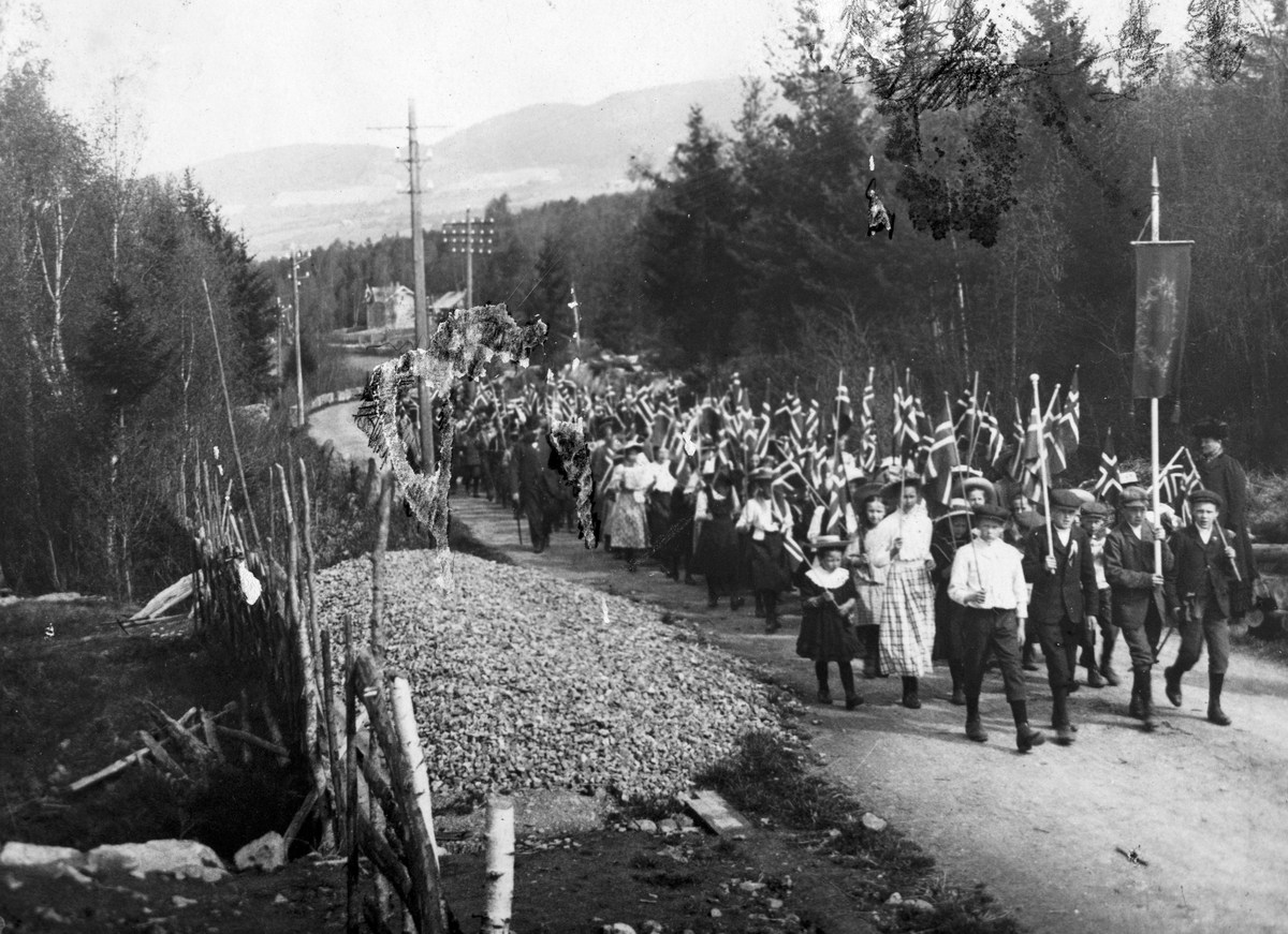 Ukjent, 17. mai-tog fra Kilde skole, Moelv ved bedehuset ca. 1920. Skoleelver med norske flagg. Lærer Andersen sees i toget.