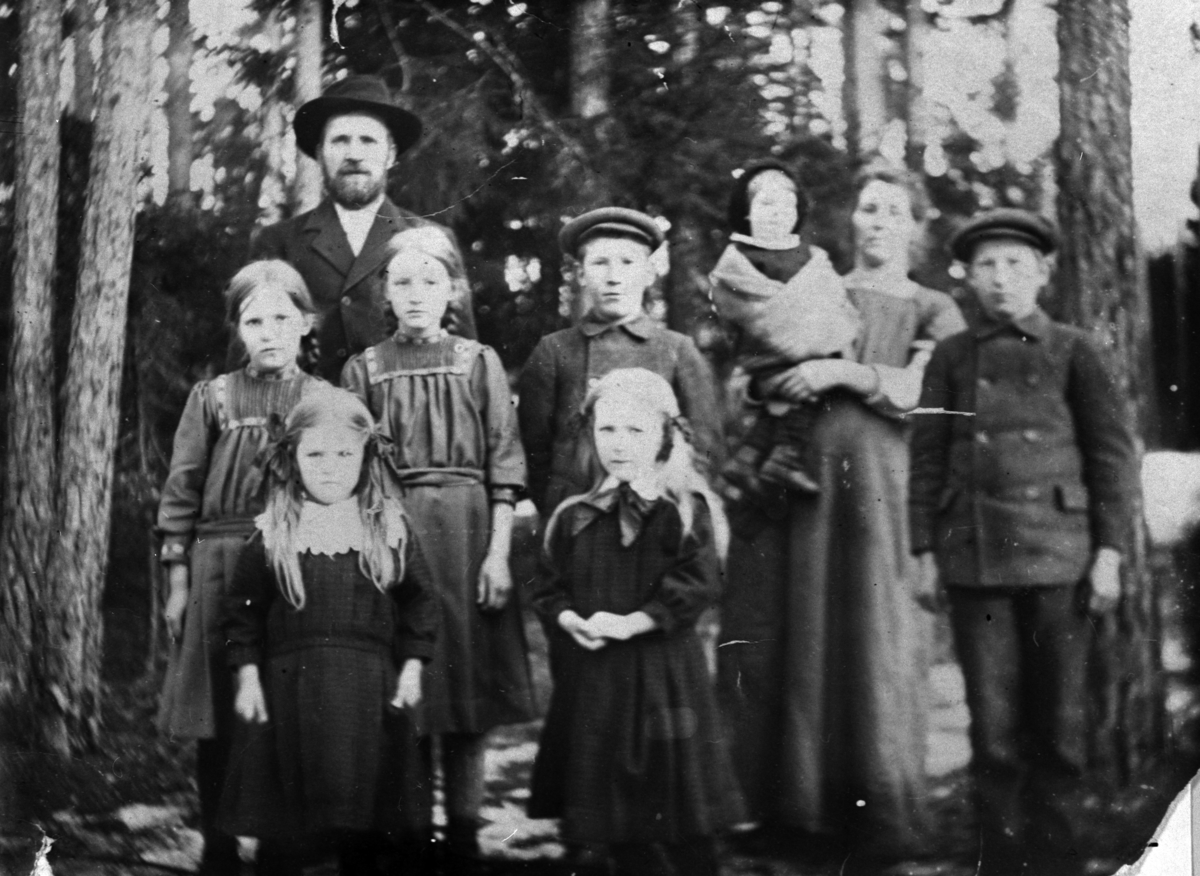 Anno Domkirkeodden, GRUPPE: 9, " MJØLNERFAMILIEN", EMIL OG KRISTIANE NILSEN MED BARNA, FORAN FRA VENSTRE: PETRA, KIRSTEN, REKKE 2: MAGDA, KAREN, OSKAR, GUNVOR PÅ ARMEN TIL MOR, KONRAD, MØLLERSTUA UNDER KVEKA.