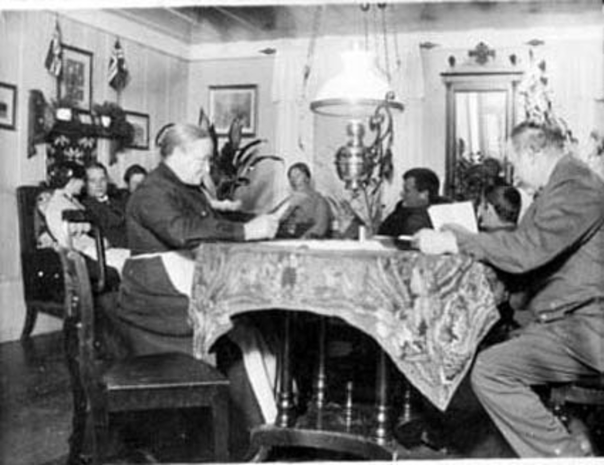 Anno Domkirkeodden, INTERIØR: STUE, MALUNGEN, SOFA, PARAFINLAMPE, SPEIL, HYLLE, BORD, STOLER, FRA VENSTRE: RAGNA BJØLSETH, HANS PEDERSEN, OLAVA BJØLSETH, EVINE BJØLSETH, BERTHE BJØLSETH, ALF BJØLSETH, BERNHARD BJØLSETH