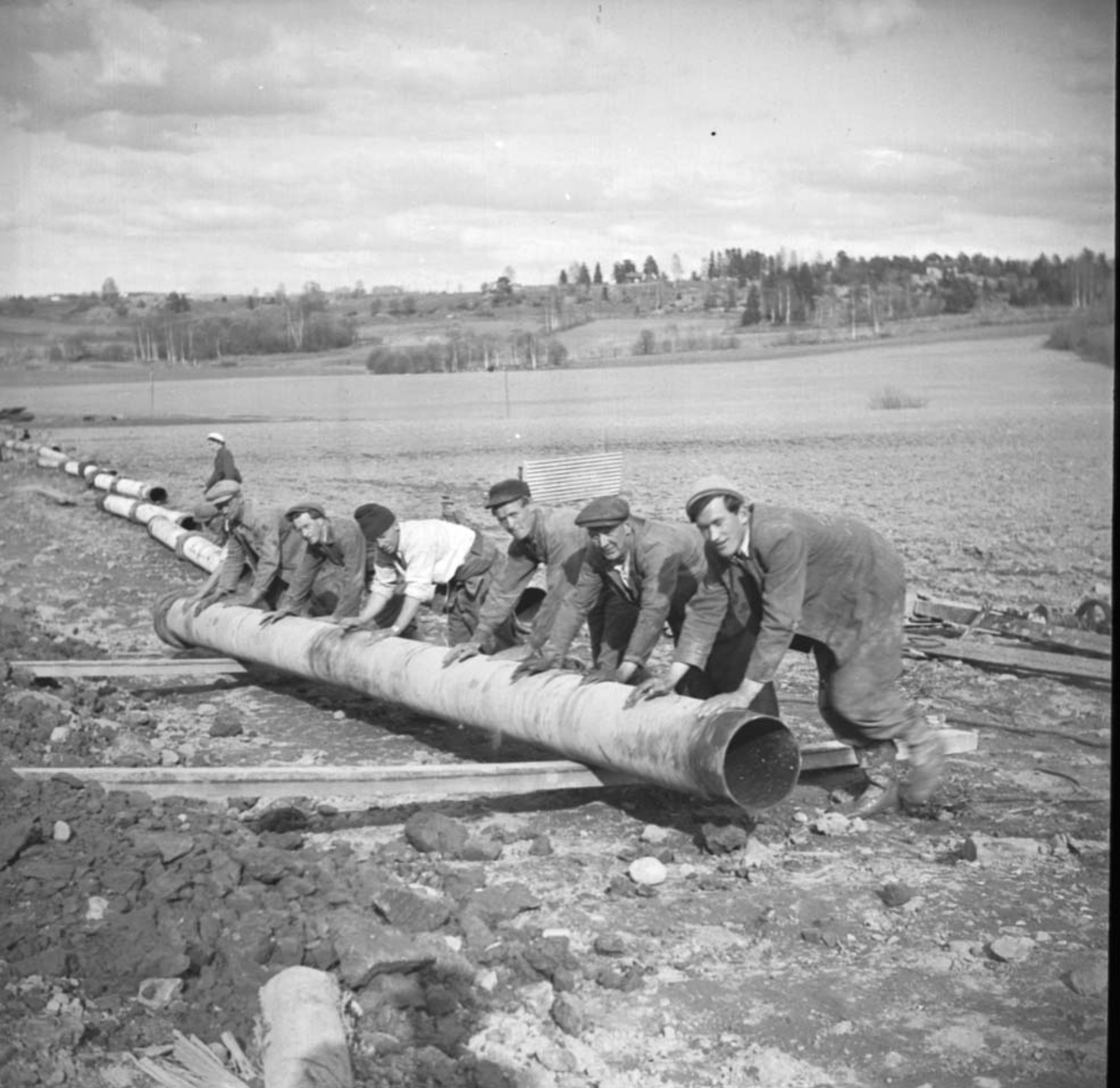 Anno Domkirkeodden, STANGE KOMMUNE, VANNVERKET, LEGGING RØR, FRANGSTUA, FRANGSTØEN, ARBEIDSLAG RULLER RØR PÅ SLIPERT. F. V. EINAR DÆHLISTUEN KRISTIANSEN, NYHAGEN, J. JOHANSEN, O. HAUG, O. SKJERBEK, G. BERG.