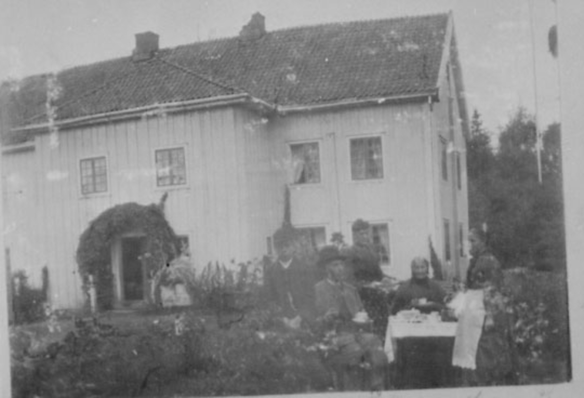 Normann Helger, EKSTERIØR: HOVEDBYGNINGEN, ØSTRE DÆHLIN, , KAFFESERVERING I HAGEN, FRA VENSTRE: NILS RIGNES, OLE RINGNES, LINA JENSEN, LENSMANNSMADAMMEN ANNE MATHEA RINGNES OG JULIE RINGNES, OTTESTAD, .