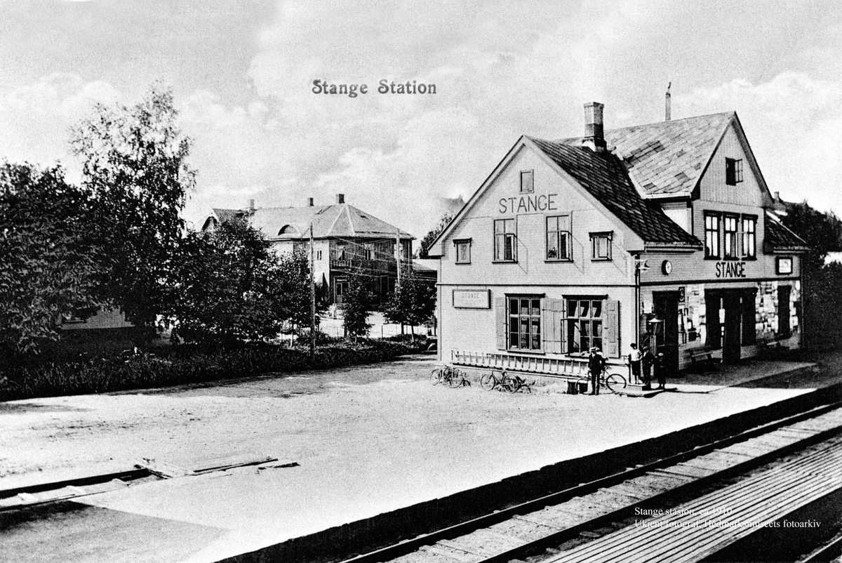 Normann Helger, EKSTERIØR: STANGE STASJON, STANGE JERNBANESTASJON, POSTKORT,