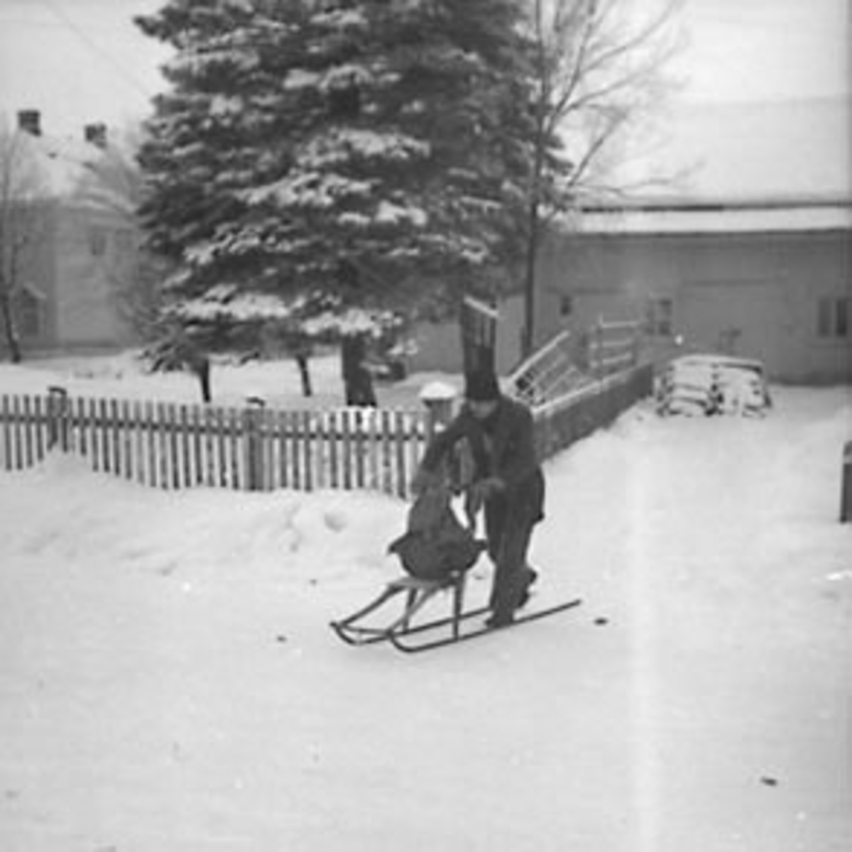 Anno Domkirkeodden, MANN MED SPARK UT FRA EIENDOMMEN FRAM I SKOLEGATA HVOR DET VAR SKOMAKERVERKSTED I UTHUSET, VINTER