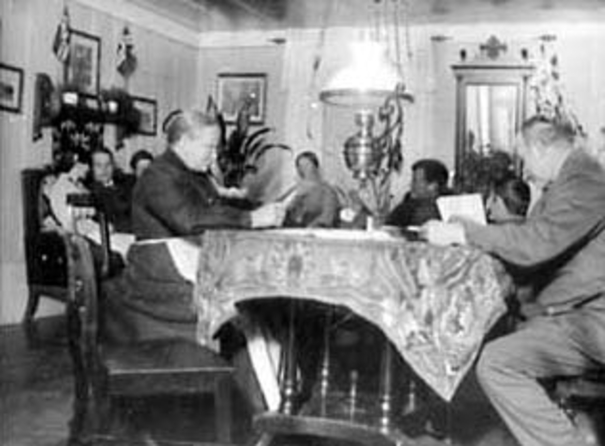 Anno Domkirkeodden, INTERIØR: STUA I KVITBYGNINGEN, MALUNGEN, SOFA, PARAFINLAMPE, SPEIL, HYLLE, BORD, STOLER, FRA VENSTRE:RAGNA BJØLSETH, HANS PEDERSEN, BAK: OLAVA, EVINE BJØLSETH, BERTHE, ALF, BERNT, BERNHARD BJØLSETH,