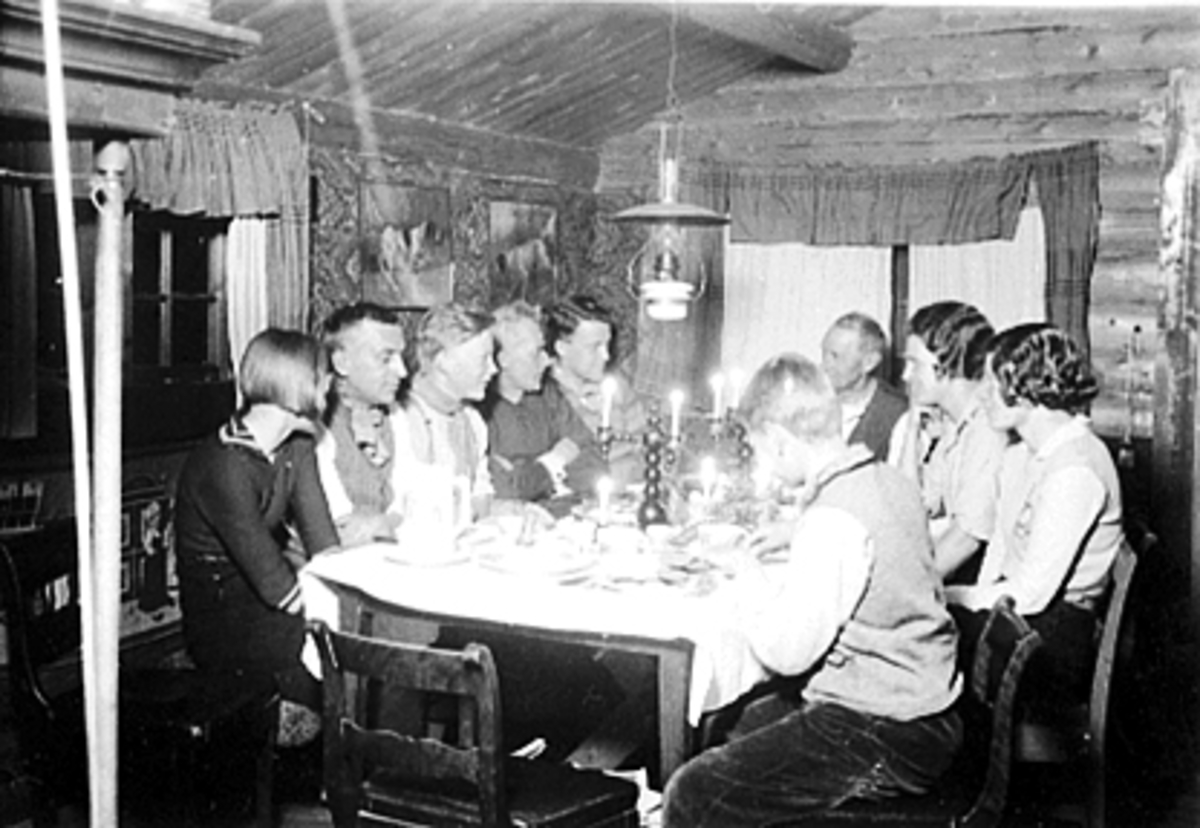 Anno Domkirkeodden, Labben, Espa. Fotograf Christian Grundseths hytte, interiør, påskeaften 1933. Måltid, middag. stearinlys, parafinlampe.. F.v. Karin Christiansen, Carl Christiansen, Ole Andreas Christiansen, K. Berger Christiansen, Odd Berger Christiansen, Christian Grundseth Liv Grundseth, Aase Christiansen, Bjørn…