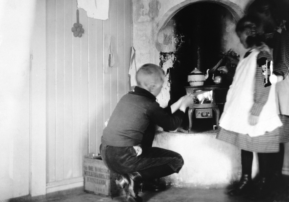 Anno Domkirkeodden, OTTESTAD GARD, STANGE, GUSTAV OG VALBORG GJESTVANG LEKER I LEKESTUE, KOKER MAT PÅ KOMFYR, BARNELEKER. I følge Ragnhild Glærum, som har skrevet en artikkel om gamle lekestuer -er ikke dette Gustav, men Oddvar Gjestvang. Søsteren Eli kan også skimtes i bakgrunnen.