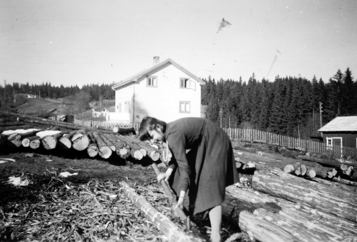 Ukjent, Skogtun, Tangen. Marit Olsen 12-13 år gammel barker tømmer. 1958.
