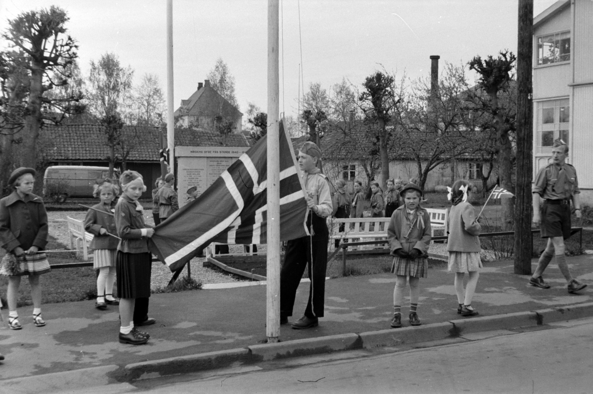 Adolf Skjegstad, STANGE, 17 MAI, SPEIDERE VED MINNESMERKE OVER DE FALNE 1940-1945, FLAGGHEISING. Asbjørg Skjegstad til høyre med trompet og 17.mai-sløyfe.