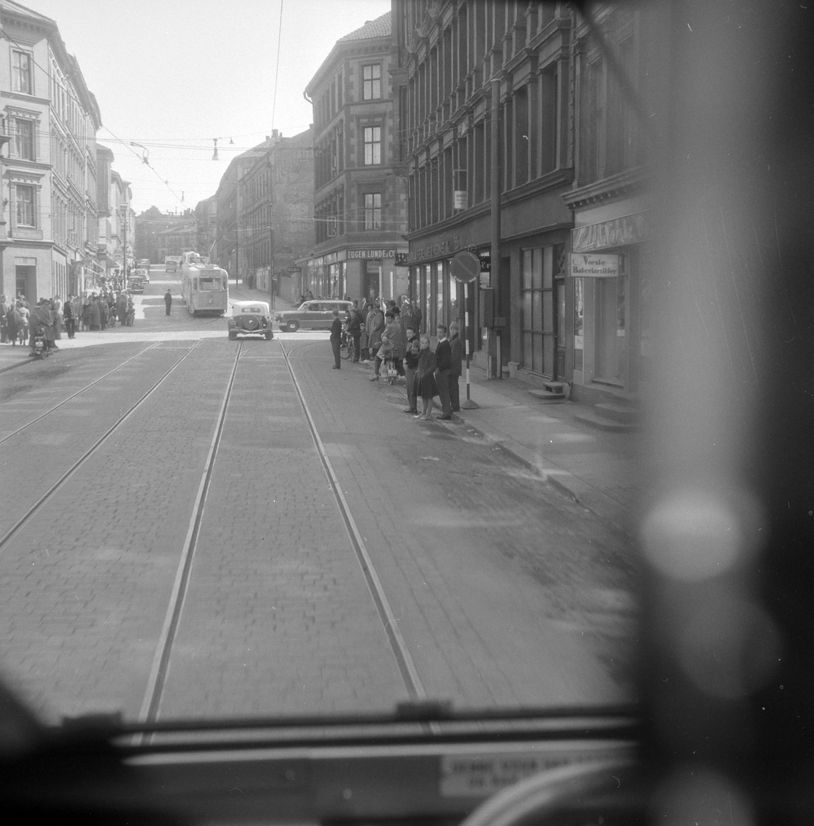 Adolf Skjegstad, Lambertseterbanen, åpning 28.04.1957. Sporvogn, trikk, bybane. Østbanen-Lamberseter. Krysset Scweigaards gate/Oslo gate. Lambertseterbanen, linje 4 fortsetter rett fram i krysset. Rutetoget på linje 4 på vei ned bakken. Trafikken ble satt på fra første ordinære vogn. Bildet er tatt fra "pressevogna…