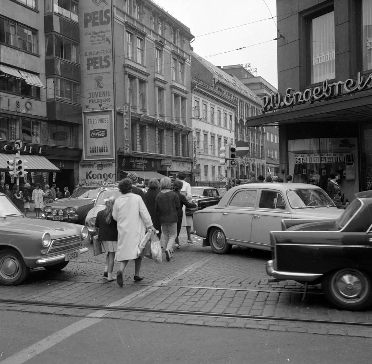 Adolf Skjegstad, I krysset mellom Lille Grensen, Grensen og Akersgata i Oslo. Biltrafikk, fotgjengere. Fra venstre: Ford Cortina, Peugeot 403, Peugeot 404. Opp Grensen kommer en Ford Taunus 17M 1961-63.