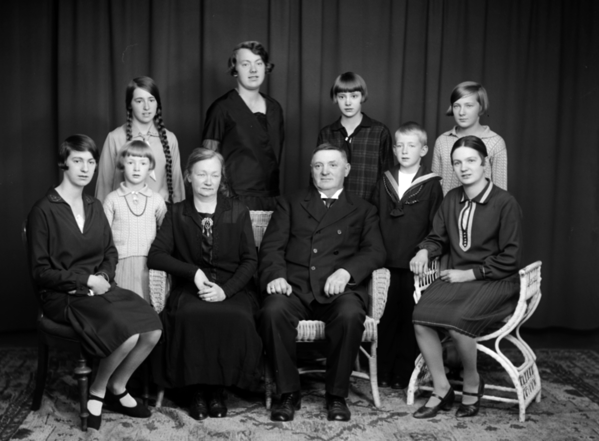 Christian Grundseth, GRUPPE 10 PERSONER. FAMILIEFOTO. MARIE OG MARTINIUS ELTON MED BARN. SITTENDE FORAN FRA VENSTRE: INGEBORG HØIVIK, MARIE ELTON, MARTINIUS ELTON, KIRSTEN RUSTAD. STÅENDE BAK FRA VENSTRE: KARI ELTON, EVA ELTON, LISBETH FULLU, RUTH SHNEIDER, OLA DÆHLIN ELTONOG ANNE MARIE HVEEM.