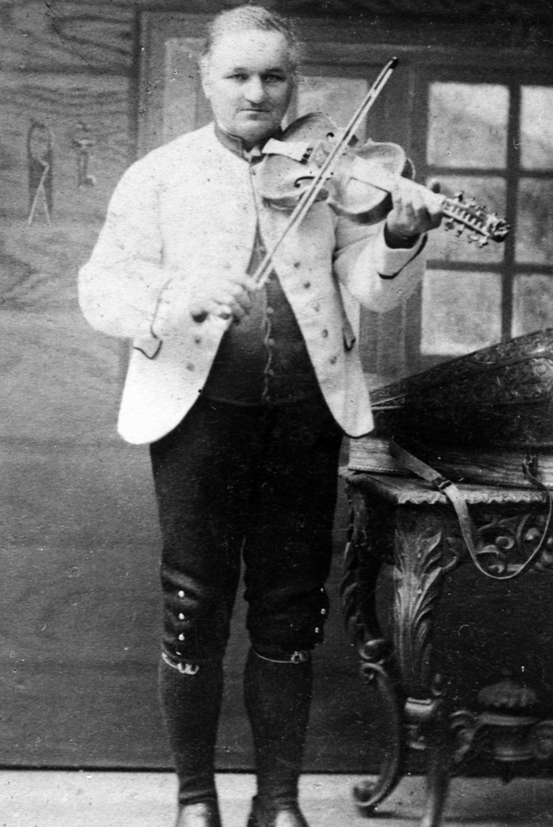 Christian Grundseth, REPRO:24098 Ola Mosafinn frå Voss. 1828-1912. MANN M/FIOLIN OG FLOTT FIOLINKASSE, HARDINGFELE, FOLKEDRAKT/BUNAD