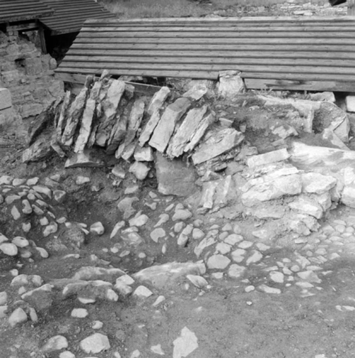 Normann Fotoatelier, Arkeologiske undersøkelser i Hamar bispegård, Domkirkeodden, Hamar 1958. Nedraste murmasser vest for tårnruinen K. HKR. 300,