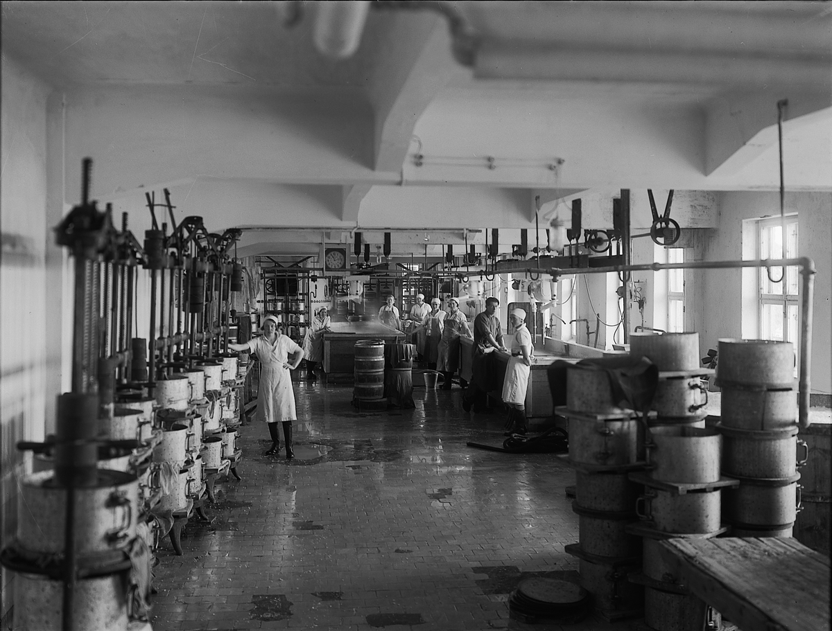 Christian Grundseth, HEDMARK MEIERI I VANGSVEGEN 185 I HAMAR. Interiør, PRODUKSJONSHALL, arbeidere i ysteriet. Formene til venstre ble brukt under produksjon av nøkkelost, mens de til høyre til goudaost. T:H foran Borghild Stavlund