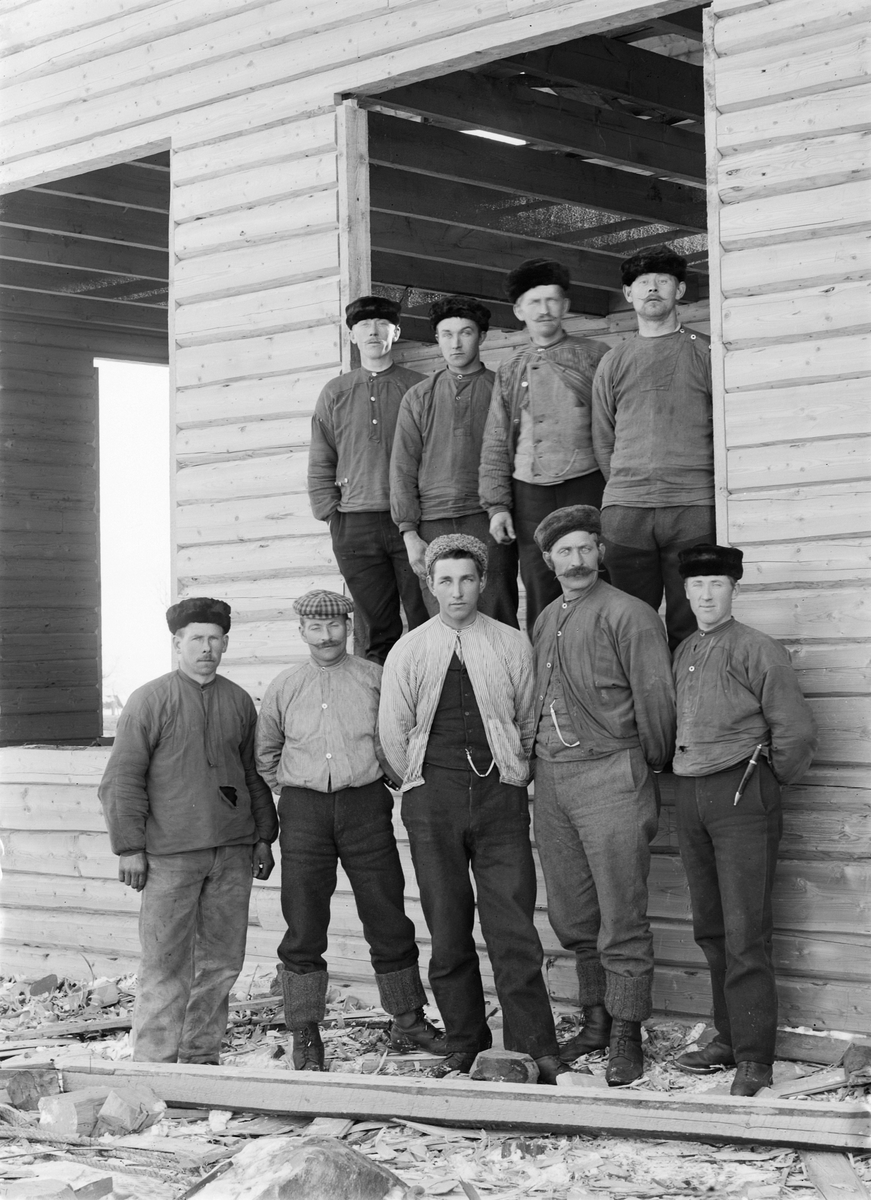 Martin Finborud, Snekkerlaget til Martin Dæhlinh (1858-1937) fra Helgøya i Ringsaker. Fremst til høyre står Karl Slåtten (1890-1975), ved siden av ham Dæhlin selv og nummer fire fra høyre: Hilmar Solbakken. De andre er ukjente. Lafting av hus, antagelig Årengen skole på Nes i 1901.