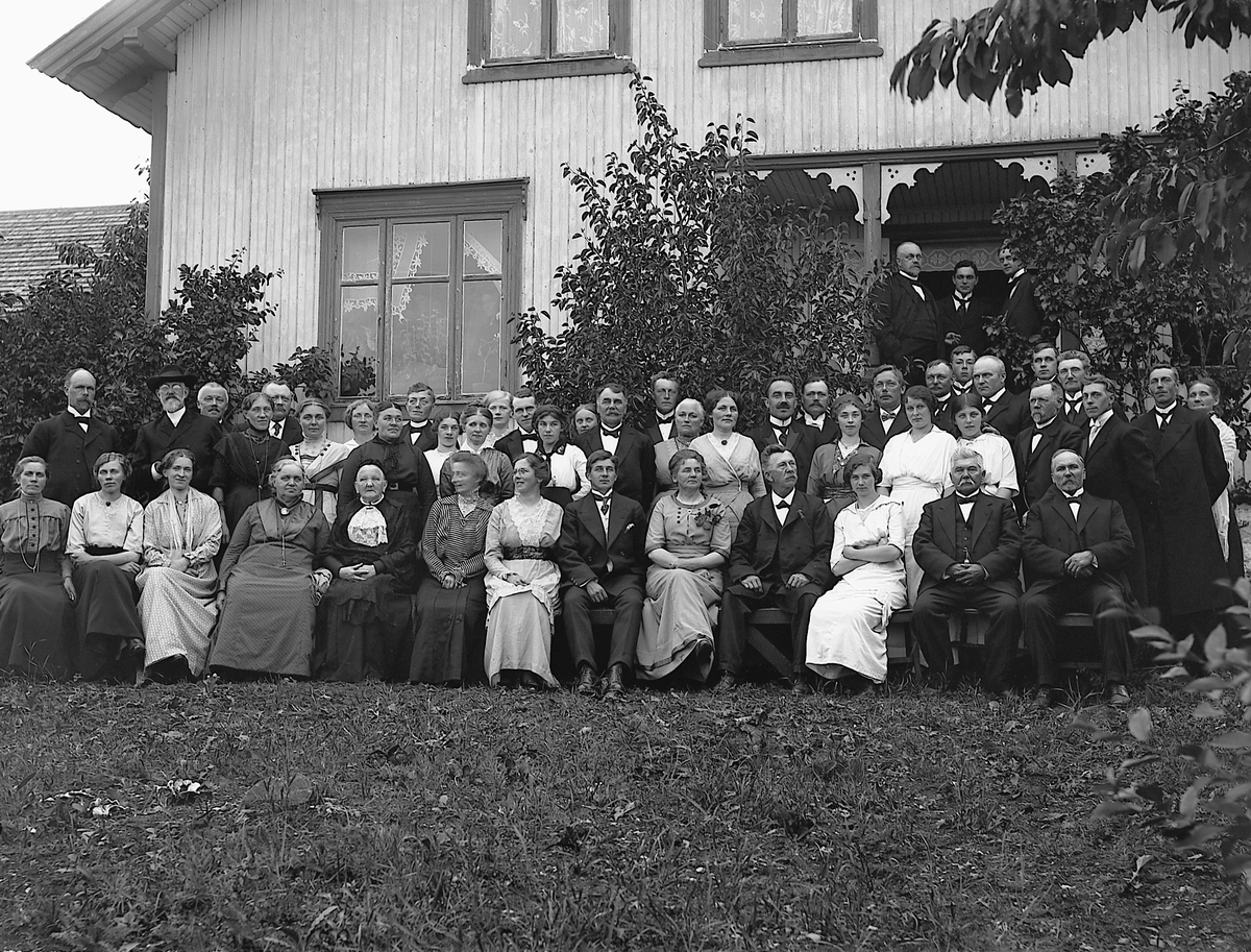 Martin Finborud, Stor gruppe ute på Lille Skjelve ved Hans Hovelsrud (1857-1936) og Marie Pedersdatter Heiberg (1864-1932) sitt sølvbryllup. Bakerst venstre, John Angell Bakken(lærer/kirkesanger)ved siden av Sogneprest Christiansen, bakerst under vindu Karl By, bakerst foran syrin Harald Hoelstad, til høyre Erik Bø…