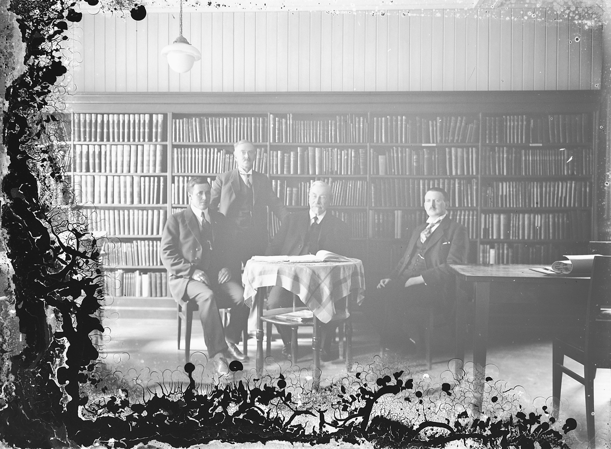 Oscar Løberg, UKJENT GRUPPE 4 PERSONER I ET BIBLIOTEK. Nr. 3 f. v. skoleinspektør Sandvig