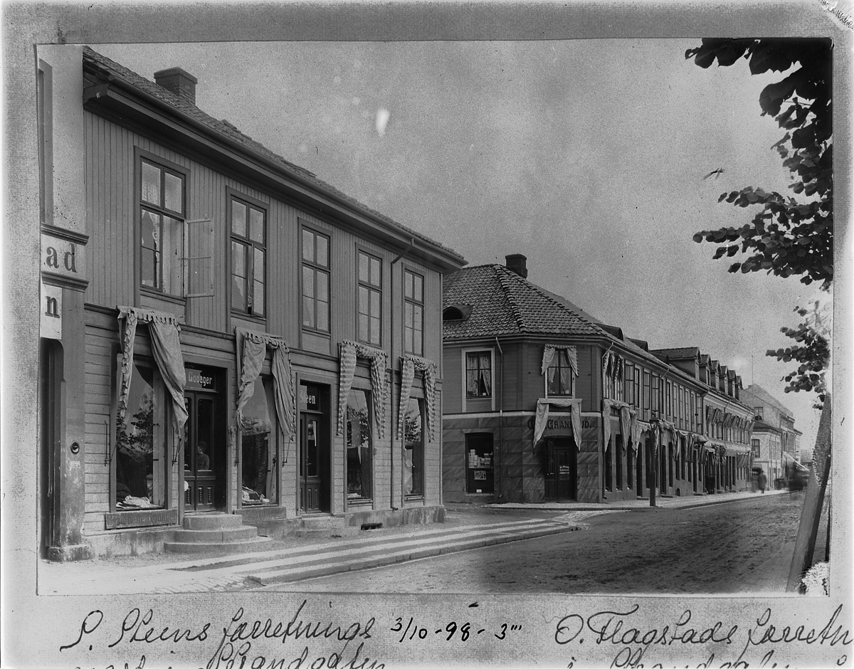 Johan Albert Steen, Hamar. Strandgata. Krysset Strandgata, Vangsvegen. Butikkene til Godager. Steen. Granerud. Midt på bygget til høyre ser man inngangen til Svaneapoteket. Det lå her fra 1887, til det flyttet det året Festiviteten ble påbegynt i 1918.