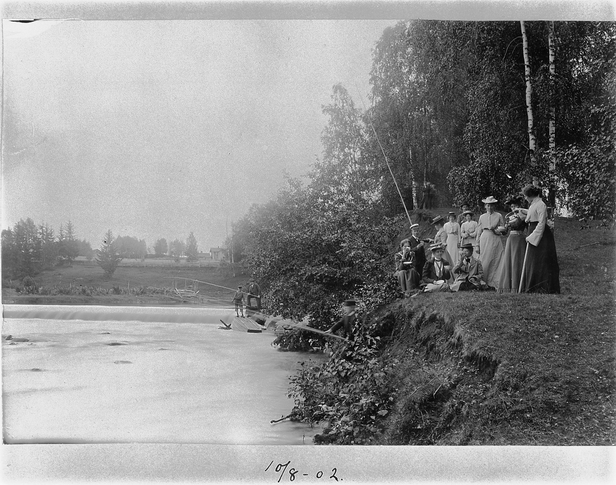 Johan Albert Steen, GRUPPE 14 UKJENTE, BARN OG VOKSNE PÅ TUR LANGS SVARTELVA, KVÆRNDAMMEN VED SANDE GÅRD, ROMEDAL. NOEN FISKER, 10-8-1902. FAMILIEN TIL KJØPMANN ALBERT STEEN.