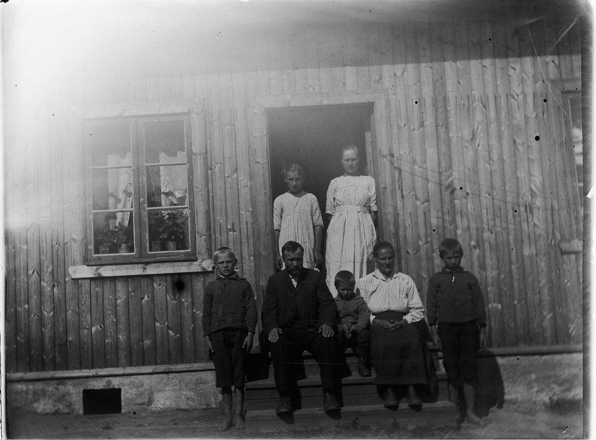 Ole M Martinsen, Ukjent gruppe, familie ved inngangen til et hus.