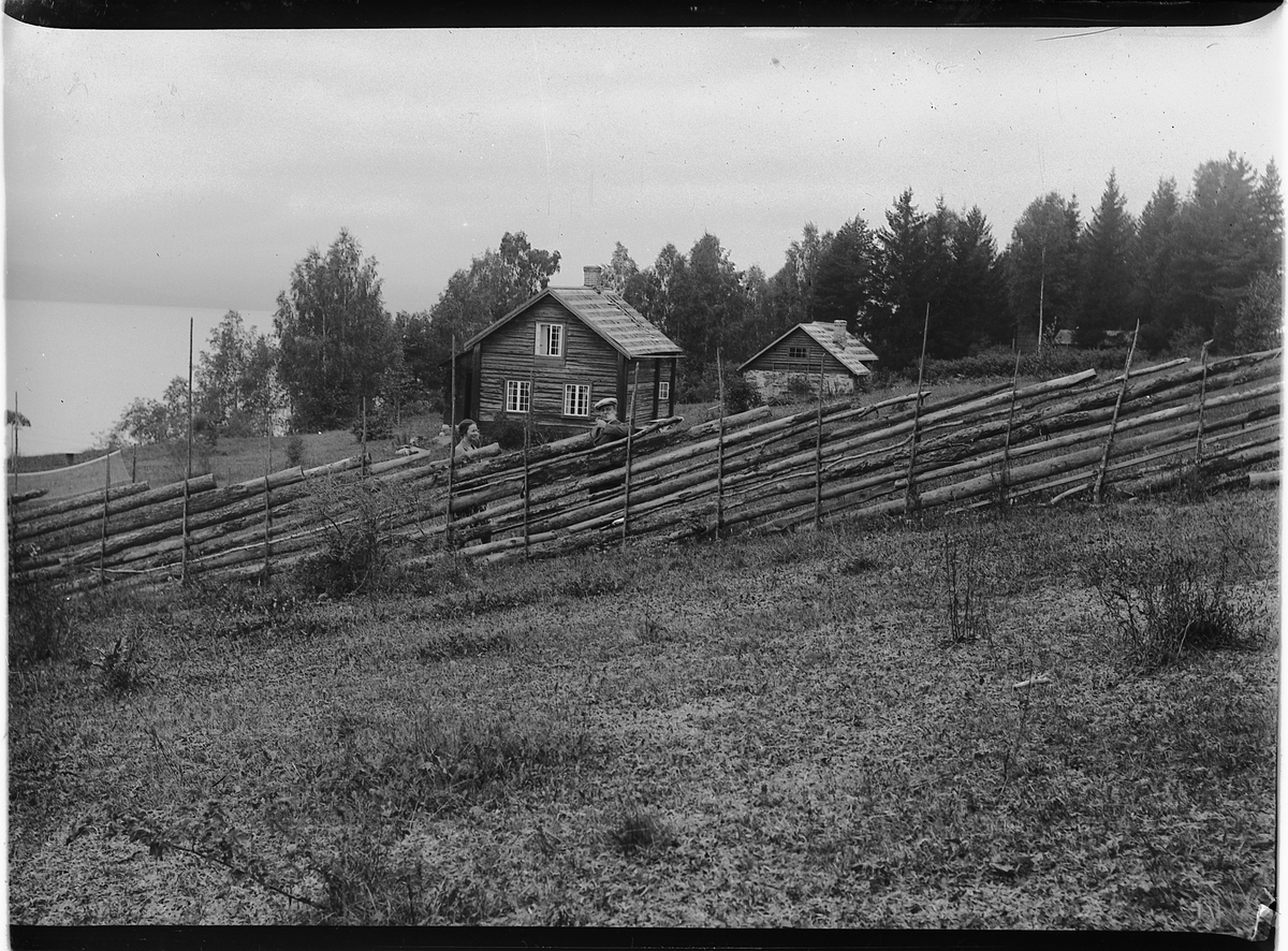 Mikkel Sveinhaug, Advokat Eivind Bredal Olssøn sitt feriested Atfor, Helgøya i 1930. 2 ukjente ved skigard.