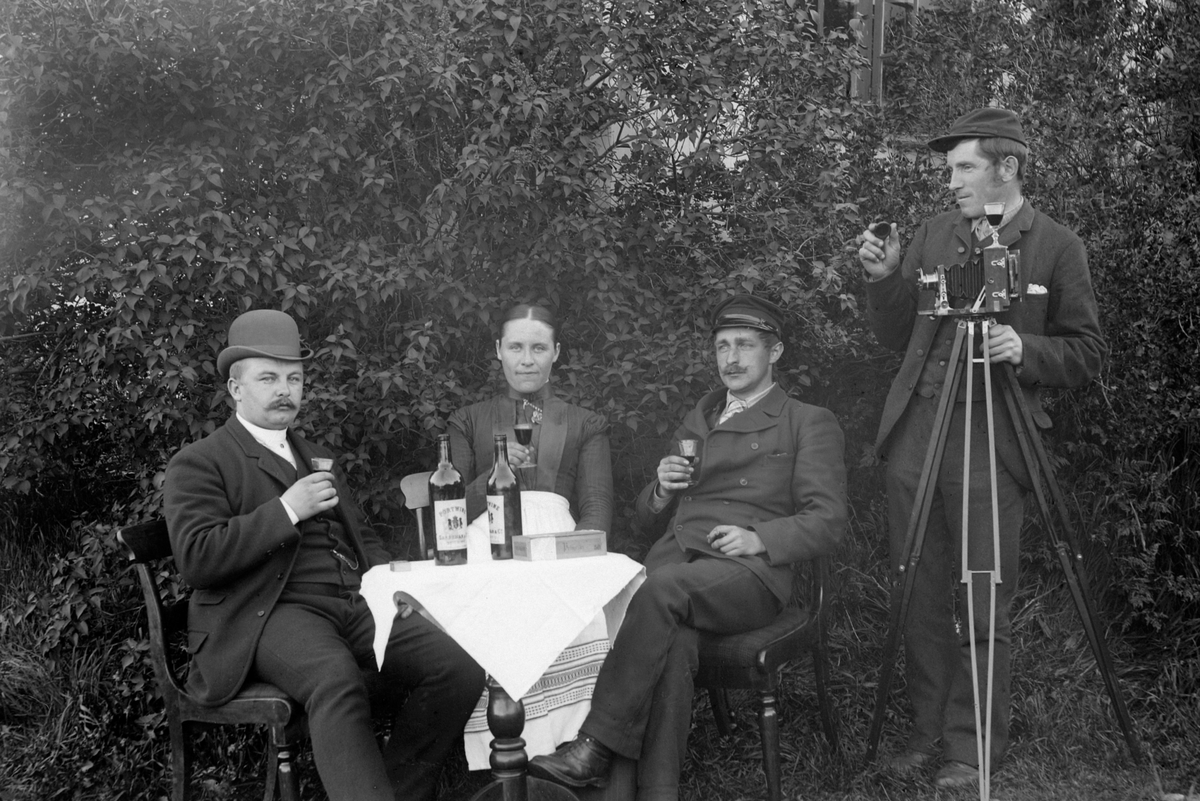 Ole Hansen Løken, OLE LØKEN MED FOTOGRAFIAPPARAT, TREKAMERA FOR GLASSPLATER, SKÅLER I VIN MED VENNER, ALKOHOL. NR. 2 F. H. FORFATTER SEVERIN LIEBLEIN, NR. 3 F. H. MARTHE GLESTAD.