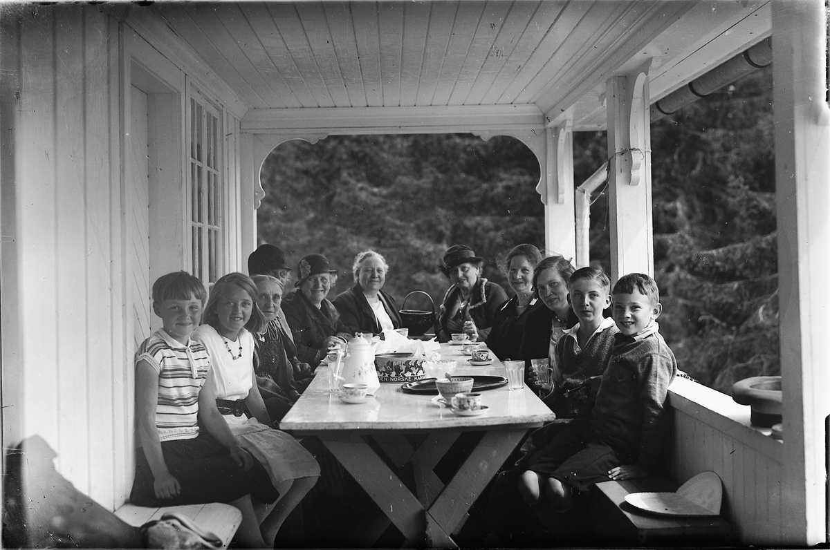 Oscar Løberg, NR. 2 F. V. BERTHA MARIE SANNERUD G. PABSDORFF, RESTEN UKJENTE BARN OG VOKSNE RUNDT KAFFFEBORD PÅ TERASSE, VERRANDA, , UKJENT STED.