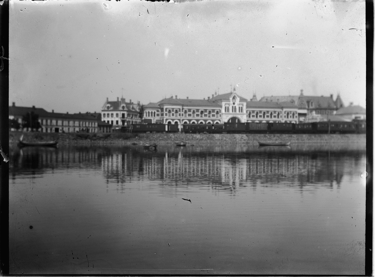 Johs. (Johannes) Johannessen, Hamar jernbanestasjon med Grand hotell til høyre, og jernbanens administrasjonsbygg til venstre.