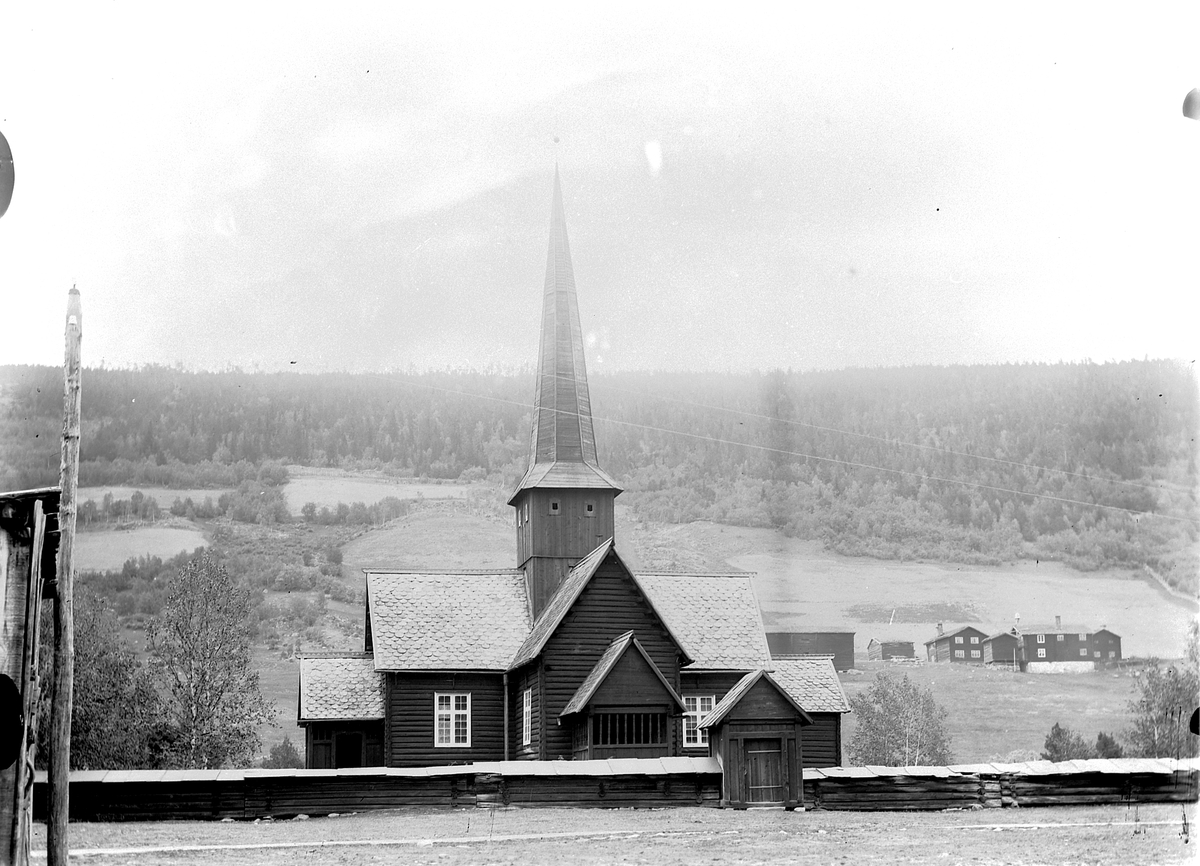 Mina Skraastad, Kirke og kirkegård med gårdsbebyggelse i åsen bakenfor. Heidal kirke.