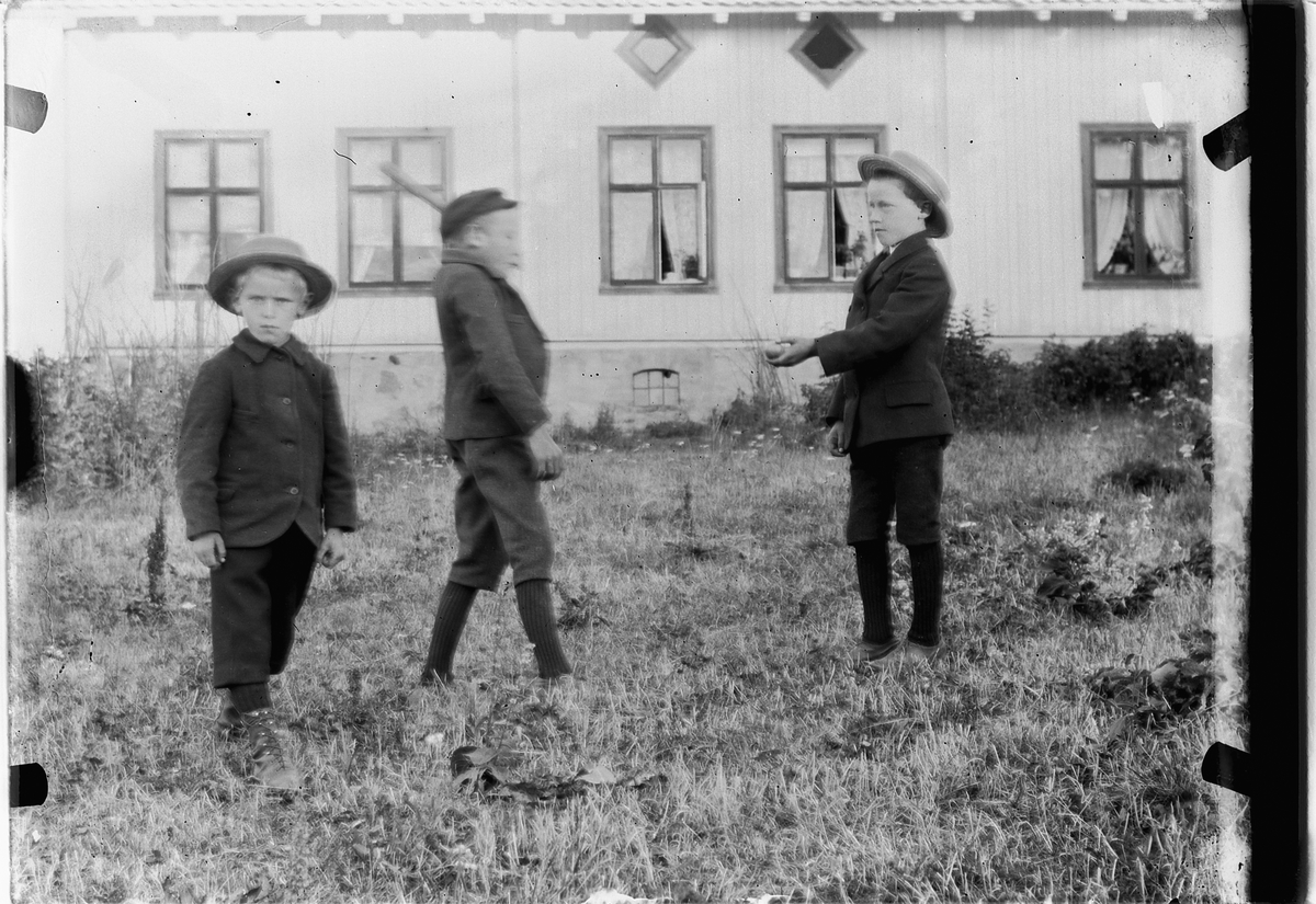 Mina Skraastad, Tre gutter foran et hus.