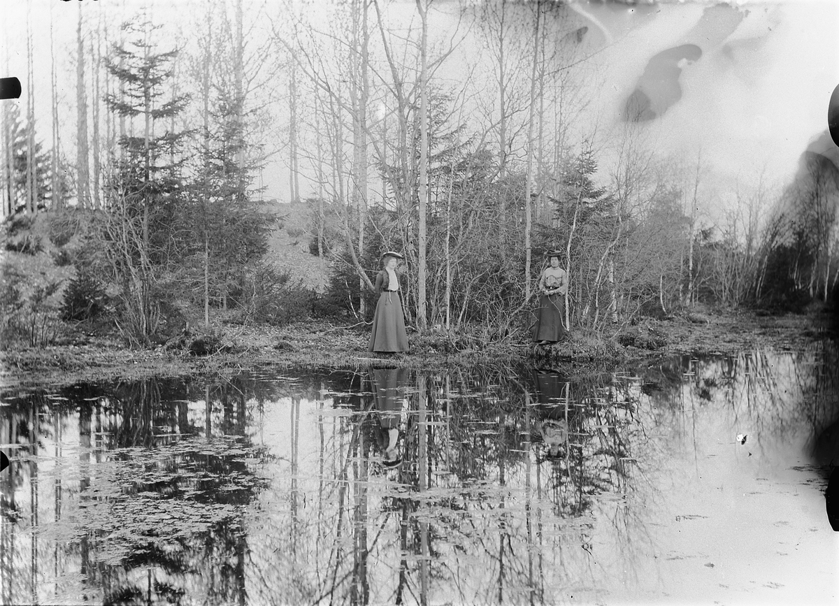 Mina Skraastad, To kvinner ved et vann i skogen.