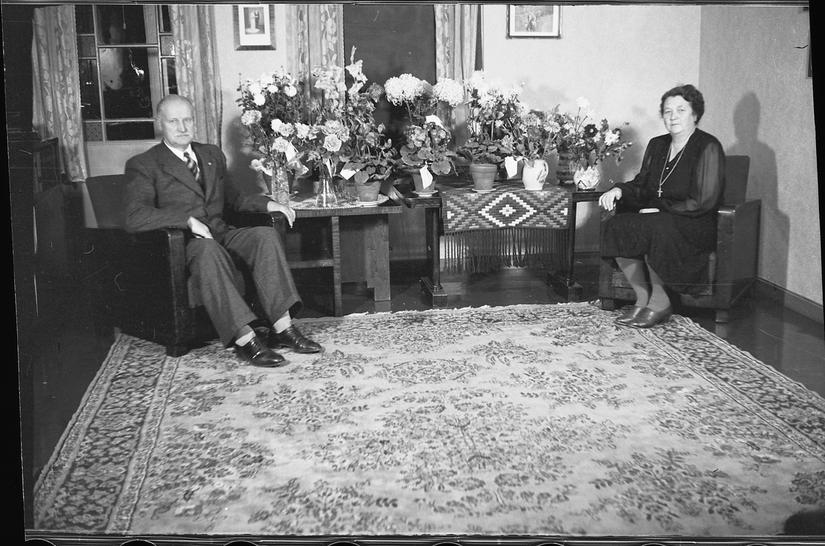 Håkon Prestkværn, Rossing, Bergh, mann og dame ved blomsterbord.
