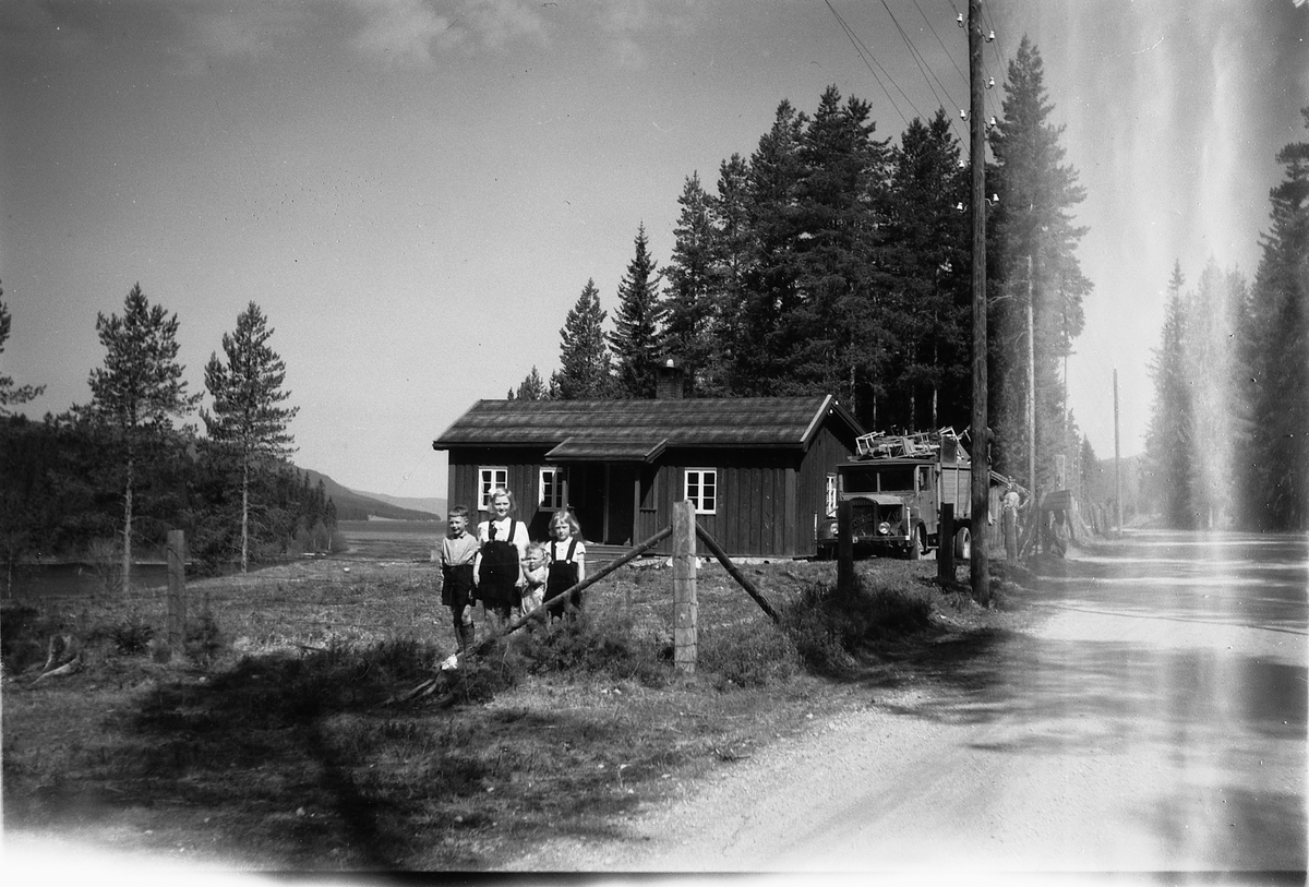 Håkon Prestkværn, Fire ukjente barn foran hus og lastebil.