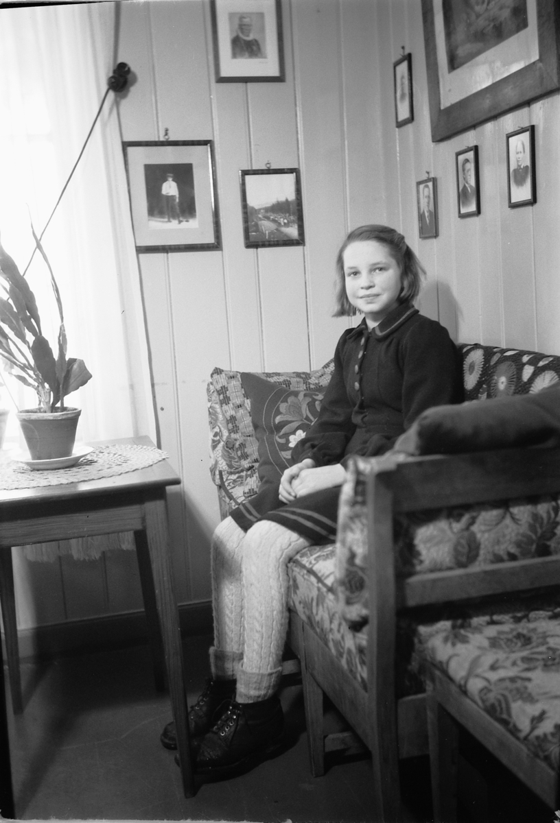 Håkon Prestkværn, Interiør, stue. Sparemøte, Syvertsen. Ukjente jente i sofa.