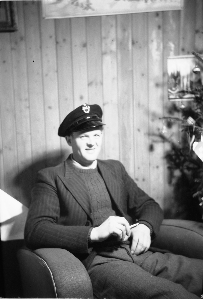 Håkon Prestkværn, Interiør, stue. Sparemøte, Syvertsen. Ukjent mann i stol.