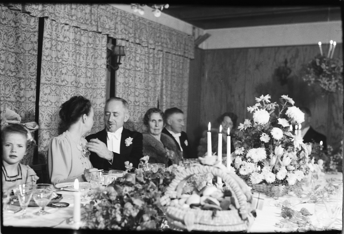 Håkon Prestkværn, Arendal, sølvbryllup. Ukjente personer ved pyntet bord med blomster og kransekake.