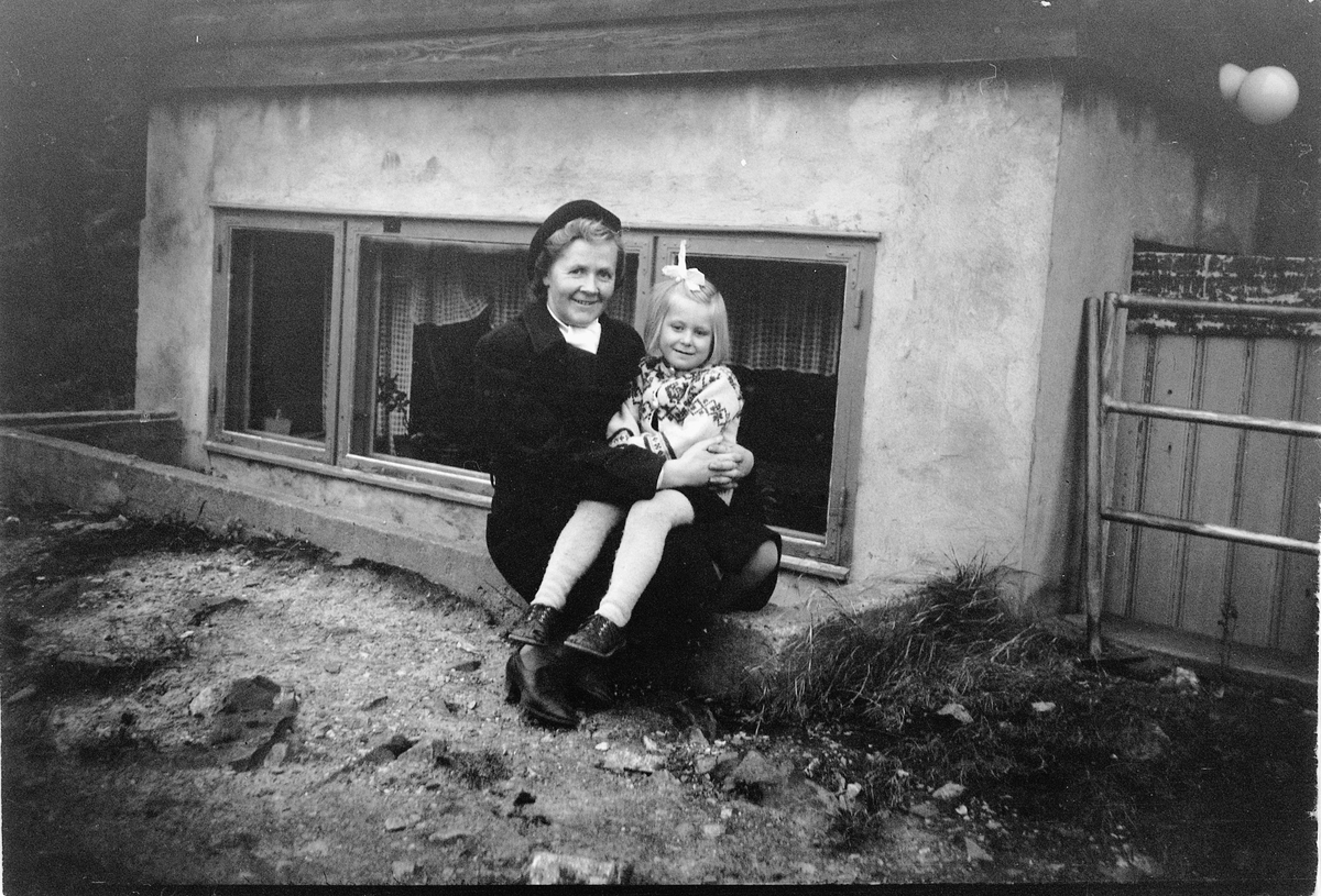 Håkon Prestkværn, Ukjent kvinne med et barn på fanget foran et hus.