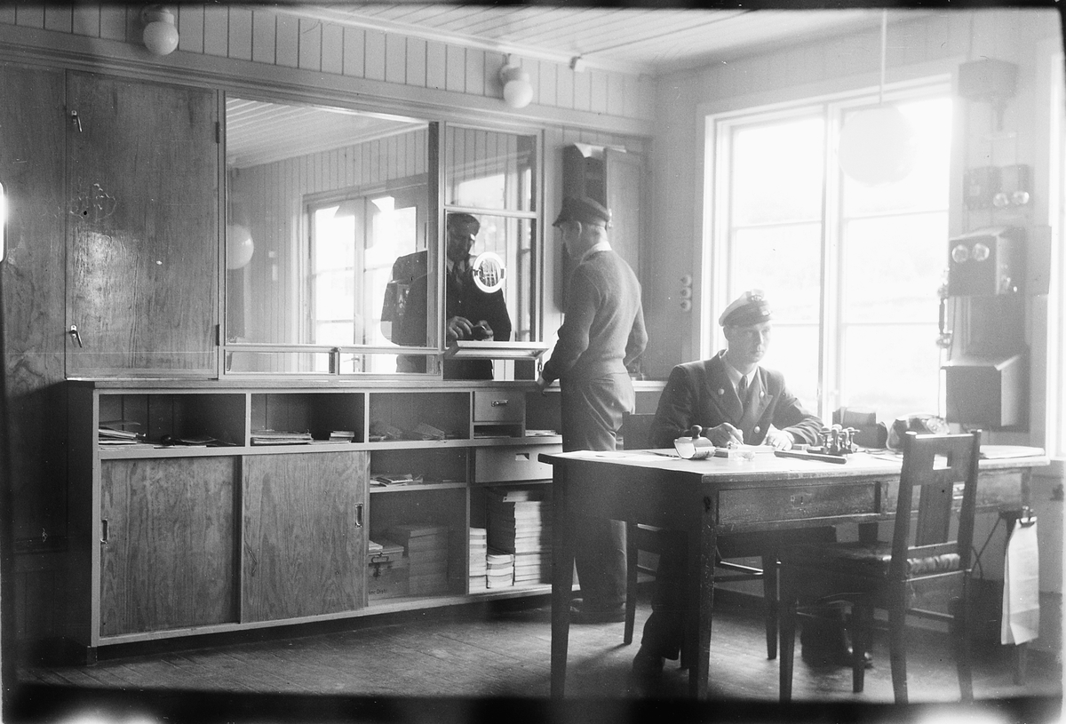 Håkon Prestkværn, Rudshøgda jernbanestasjon, Ringsaker. Interiør, kontor, billettluke, stasjonsmester Magne Pedersen, kontorpult, telefon. Andreas Andreassen ? i billettluke, ekspedisjon