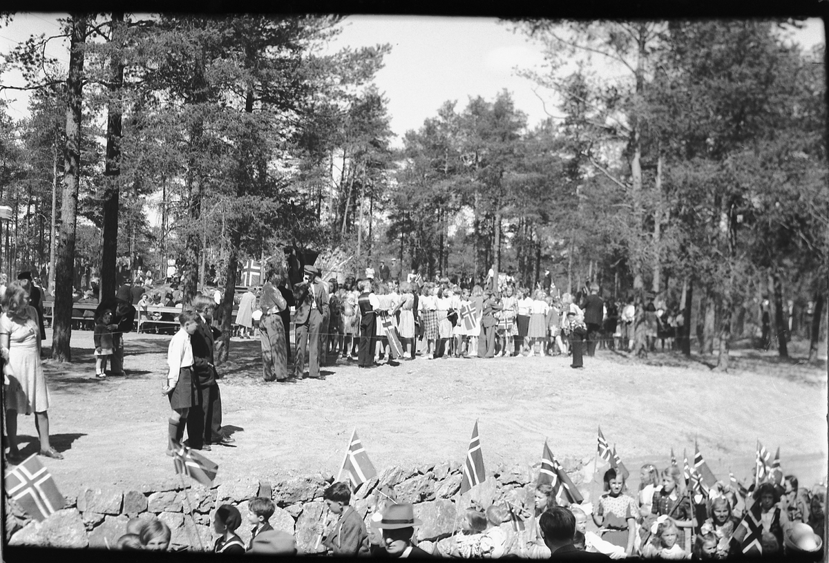 Håkon Prestkværn, 17. mai i Moelv. Masse mennesker samlet med norske flagg.