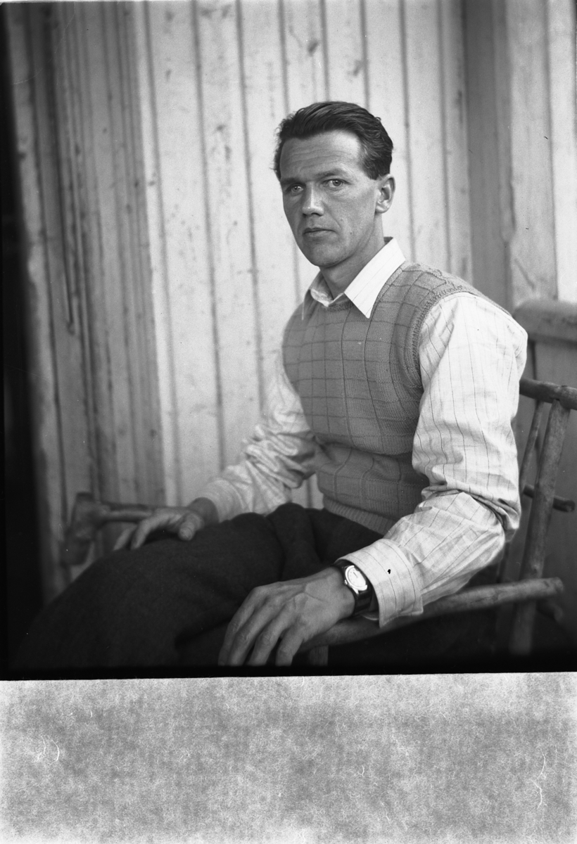 Håkon Prestkværn, Ukjent mann sitter i en stol på trammen.